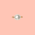 White freshwater pearl connector charm with gold-filled rings on a pink background