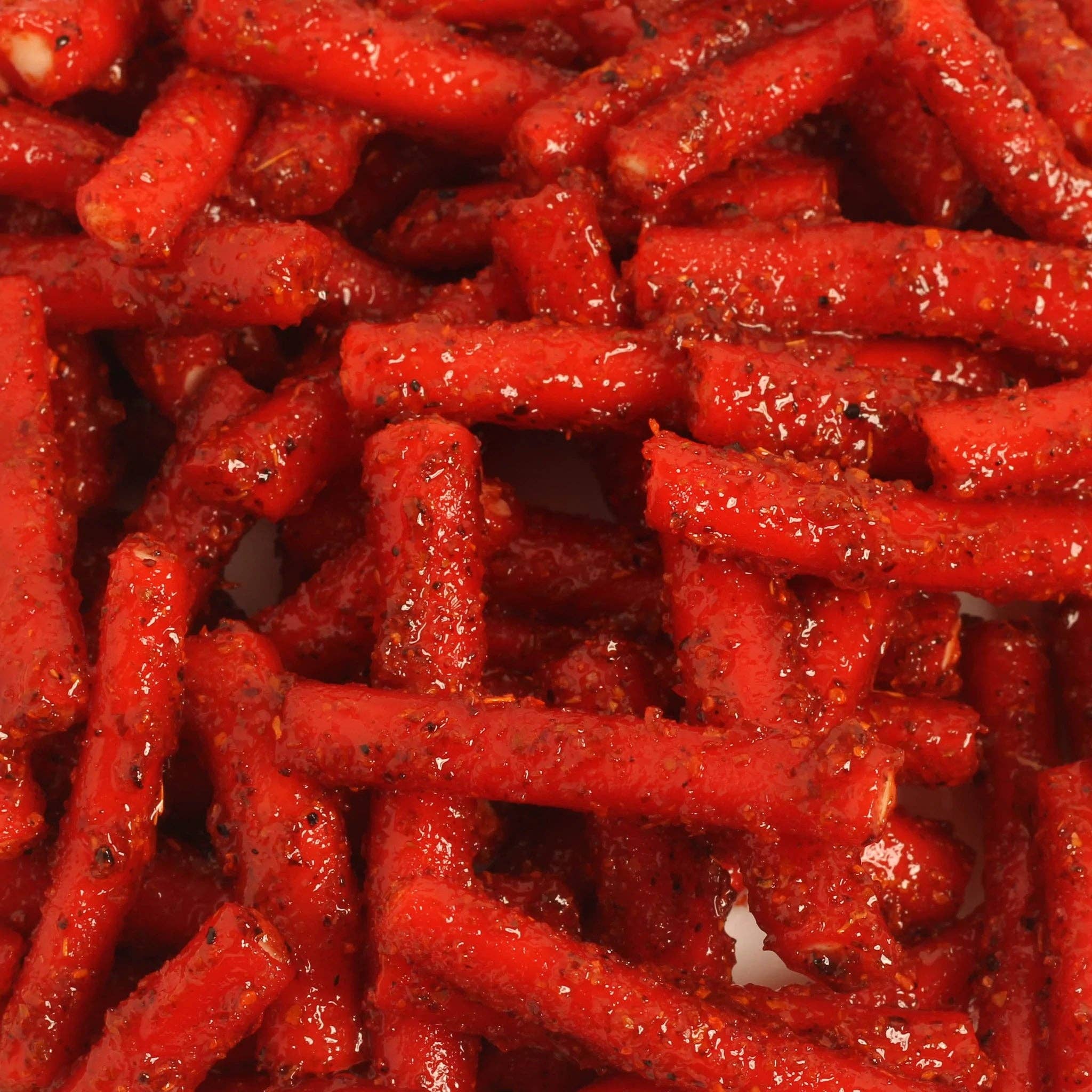 Spicy Strawberry Tubes filled with vanilla and coated in chamoy chili. Sweet, sour, and spicy candy with bold flavor. Made fresh weekly in the USA.
