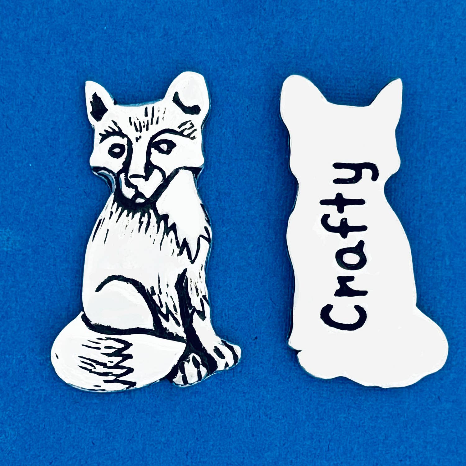 Meet your new favorite pocket companion! Keep it in your bag or use it to decorate your home. On one side, a beautifully detailed fox sits in quiet observation, while the other side cheekily reads 'Crafty.'

Fine hand-crafted pewter, made in Canada.