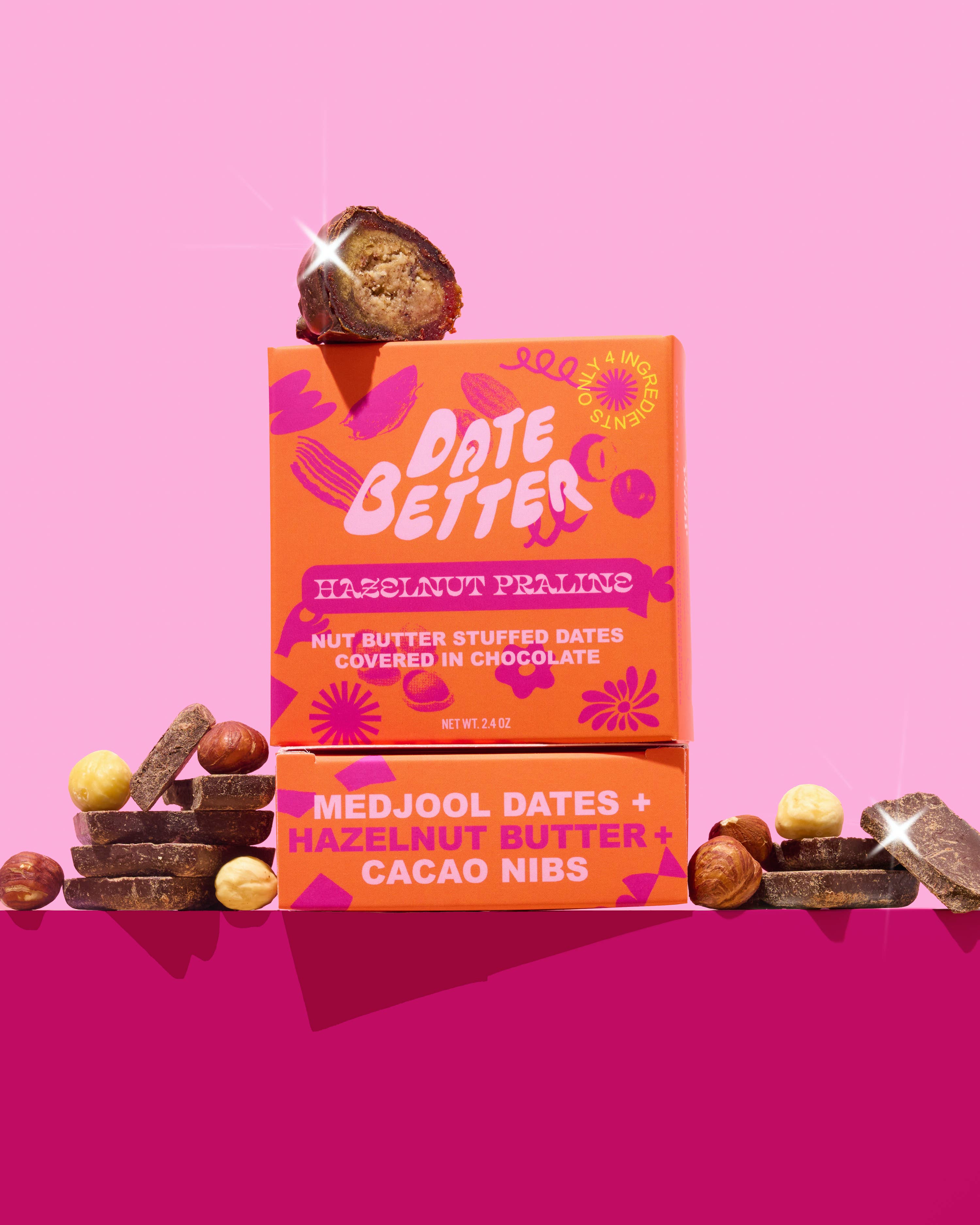Orange packaging of 'Date Better' with dates and hazelnuts on a pink background