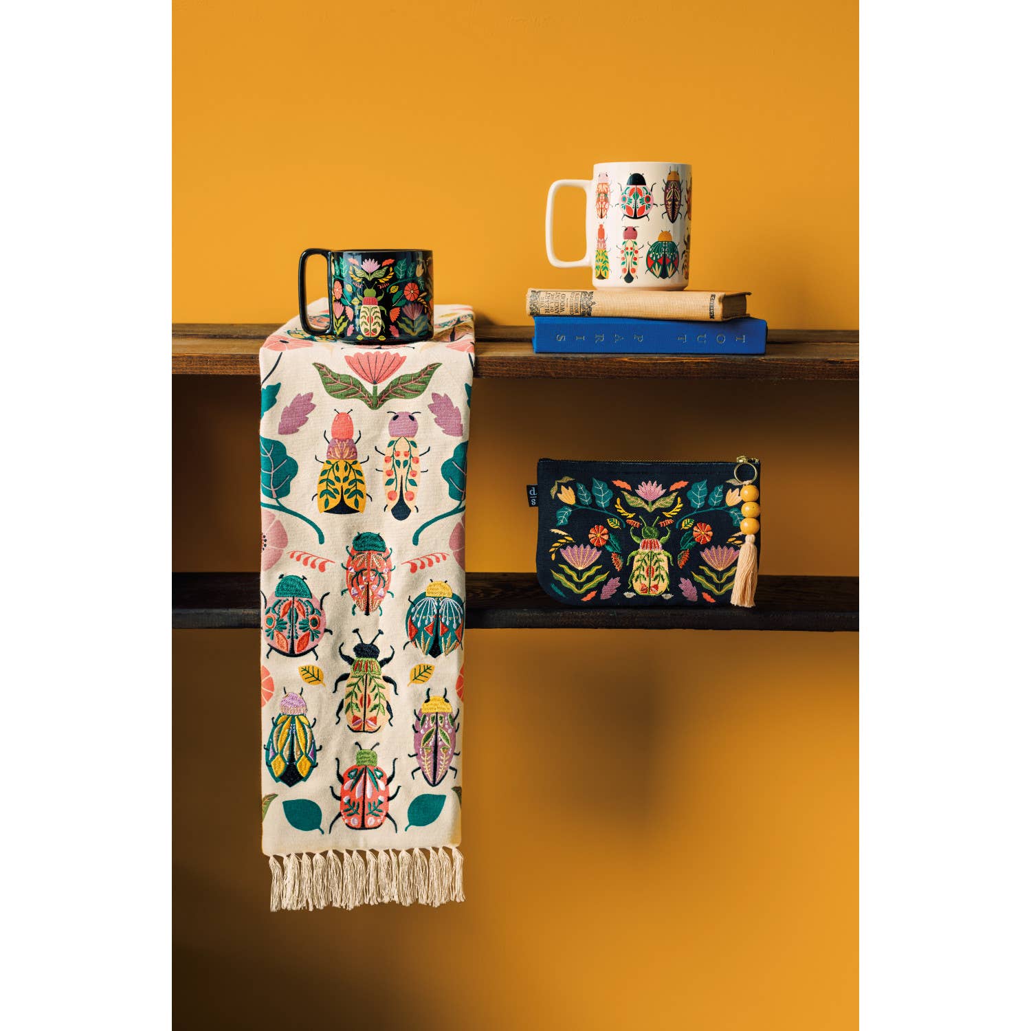 Add charm and protection to your kitchen with the Amulet Embroidered Dishtowel. Featuring insects, reptiles, flowers, and feathers in vibrant hues with playful tassels.