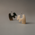Pair of brass Més stud hoops standing on a gray surface