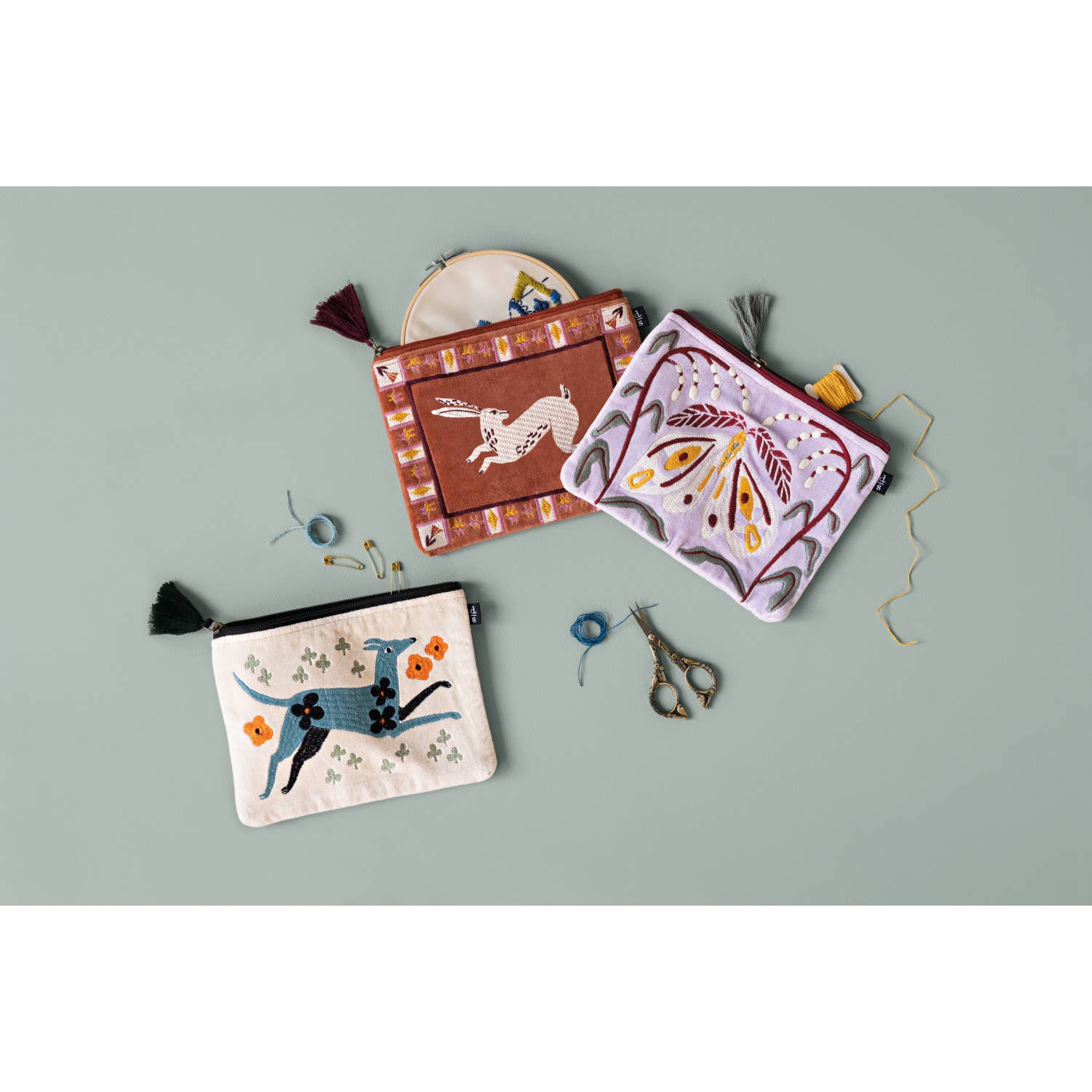 Tucked in a tote or at hand on the vanity, this pouch with embroidered design and tassel detail give everyday routines a beautiful boost. Detailed borders outline this creature's story with an intricate, tile-like frame. Follow the hare into a land where imagination wanders and worldly wisdom is shared through tales as old as time with this design from the Folktale Collection.