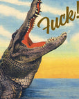 Crocodile with open mouth and 'F**k!' text against a sunset sky