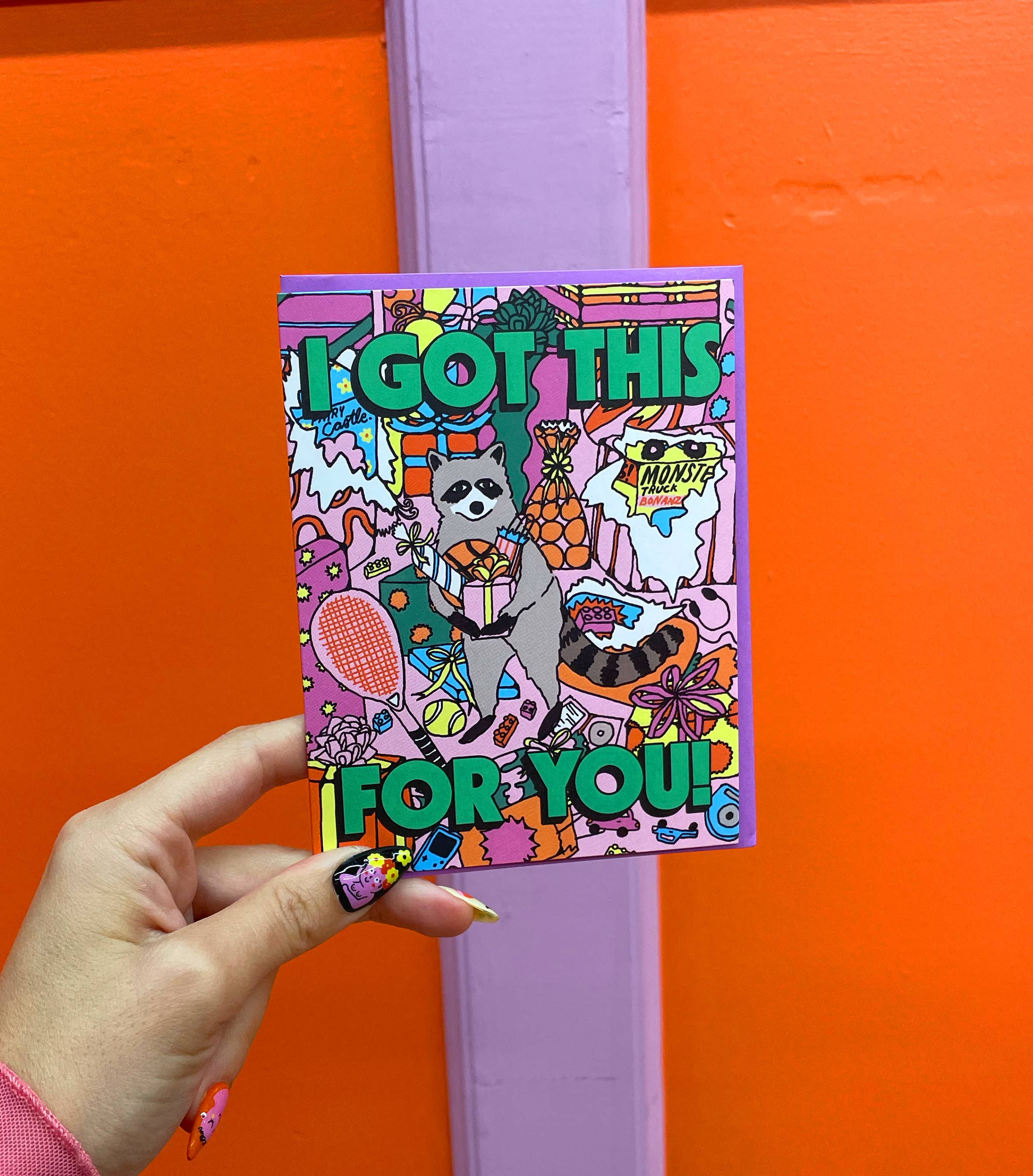 Colorful card with cartoon characters and text held against an orange background