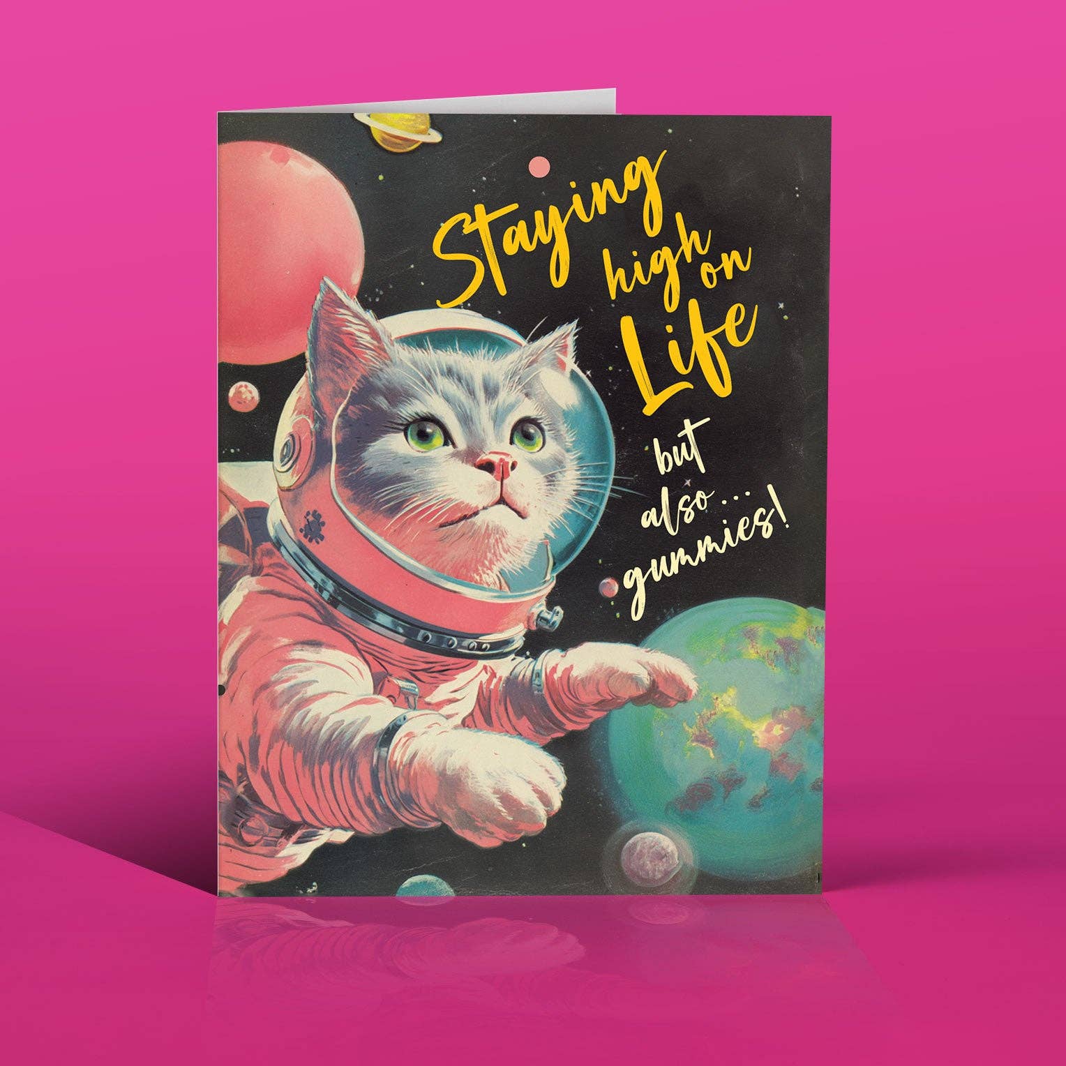Card with a cat in an astronaut suit and space-themed text on a pink background