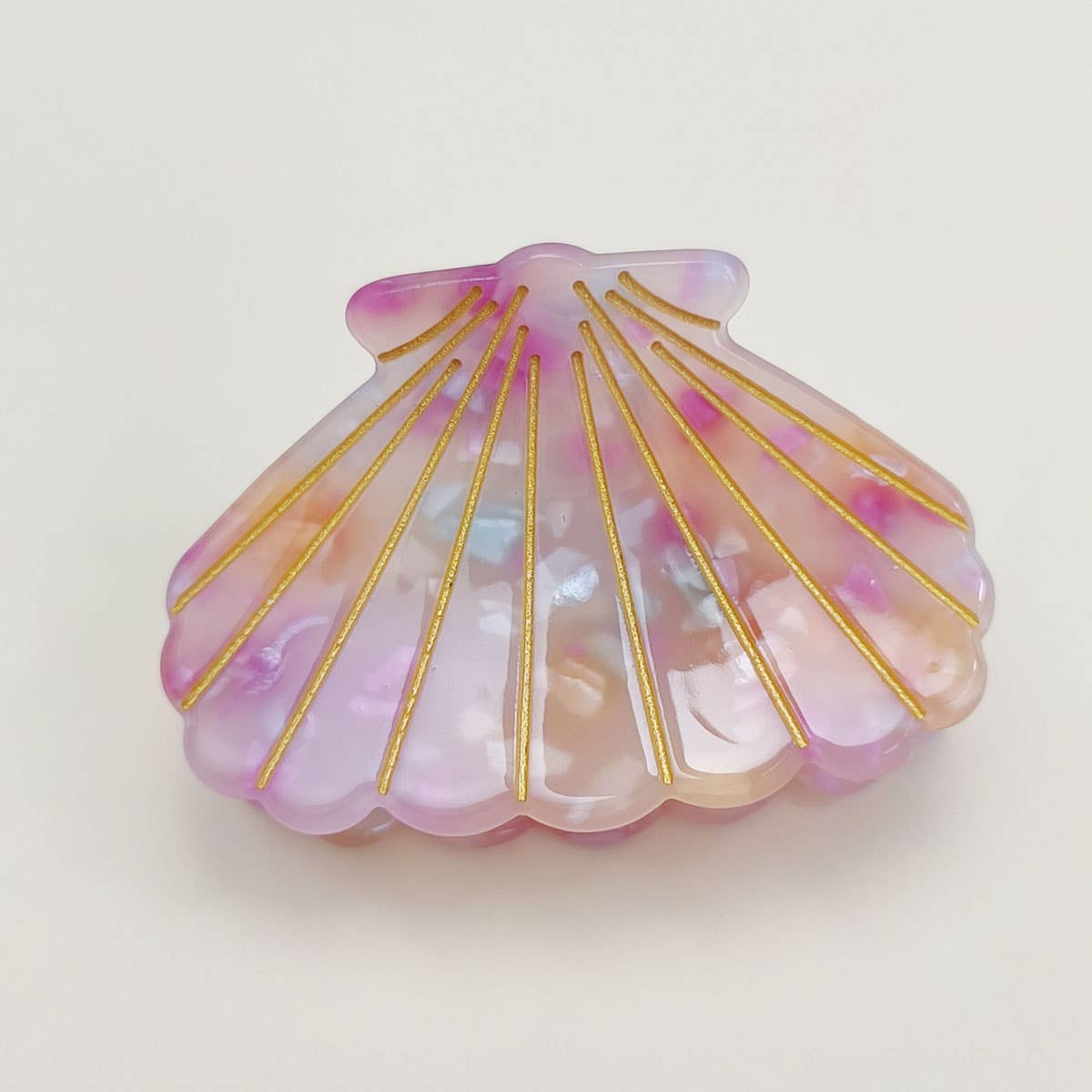 Bring a touch of beachy charm to your hairstyle with this pink shell-shaped hair claw clip. Made from lightweight acrylic, it holds hair securely while adding a playful, summery accent to any look. Perfect for everyday wear or for layering with other clips for a fun, stylish statement.