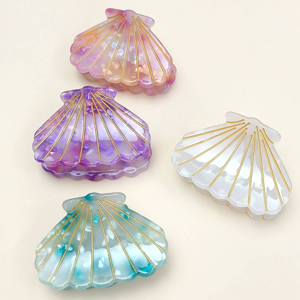 Bring a touch of beachy charm to your hairstyle with this pink shell-shaped hair claw clip. Made from lightweight acrylic, it holds hair securely while adding a playful, summery accent to any look. Perfect for everyday wear or for layering with other clips for a fun, stylish statement.