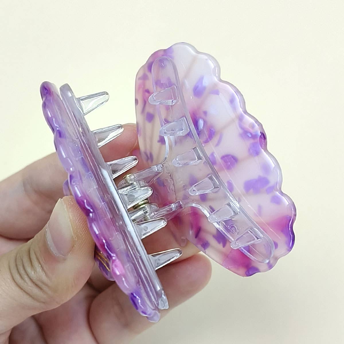 Bring a touch of beachy charm to your hairstyle with this pink shell-shaped hair claw clip. Made from lightweight acrylic, it holds hair securely while adding a playful, summery accent to any look. Perfect for everyday wear or for layering with other clips for a fun, stylish statement.