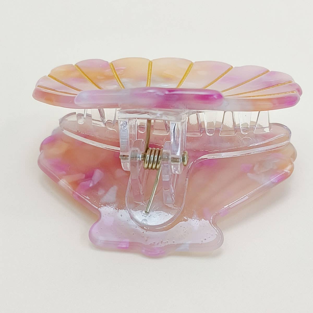 Bring a touch of beachy charm to your hairstyle with this pink shell-shaped hair claw clip. Made from lightweight acrylic, it holds hair securely while adding a playful, summery accent to any look. Perfect for everyday wear or for layering with other clips for a fun, stylish statement.
