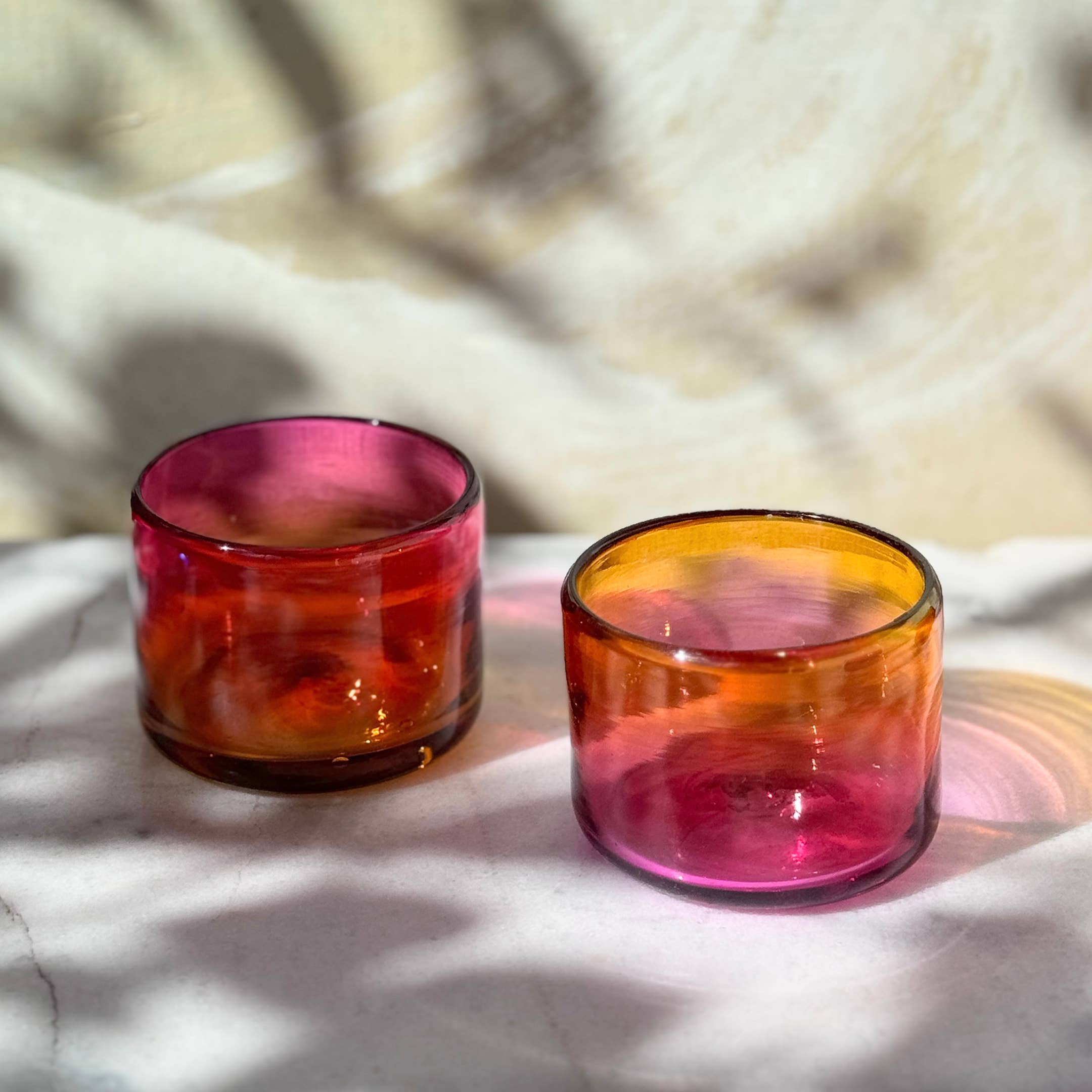 This vibrant, ombré pink and orange tumbler is hand blown in a family-run workshop, making each piece truly one-of-a-kind. Subtle variations in size and color mean no two are alike. Perfect for wine, cocktails, or even as a charming candle holder, it brings a touch of artistry and personality to any table.