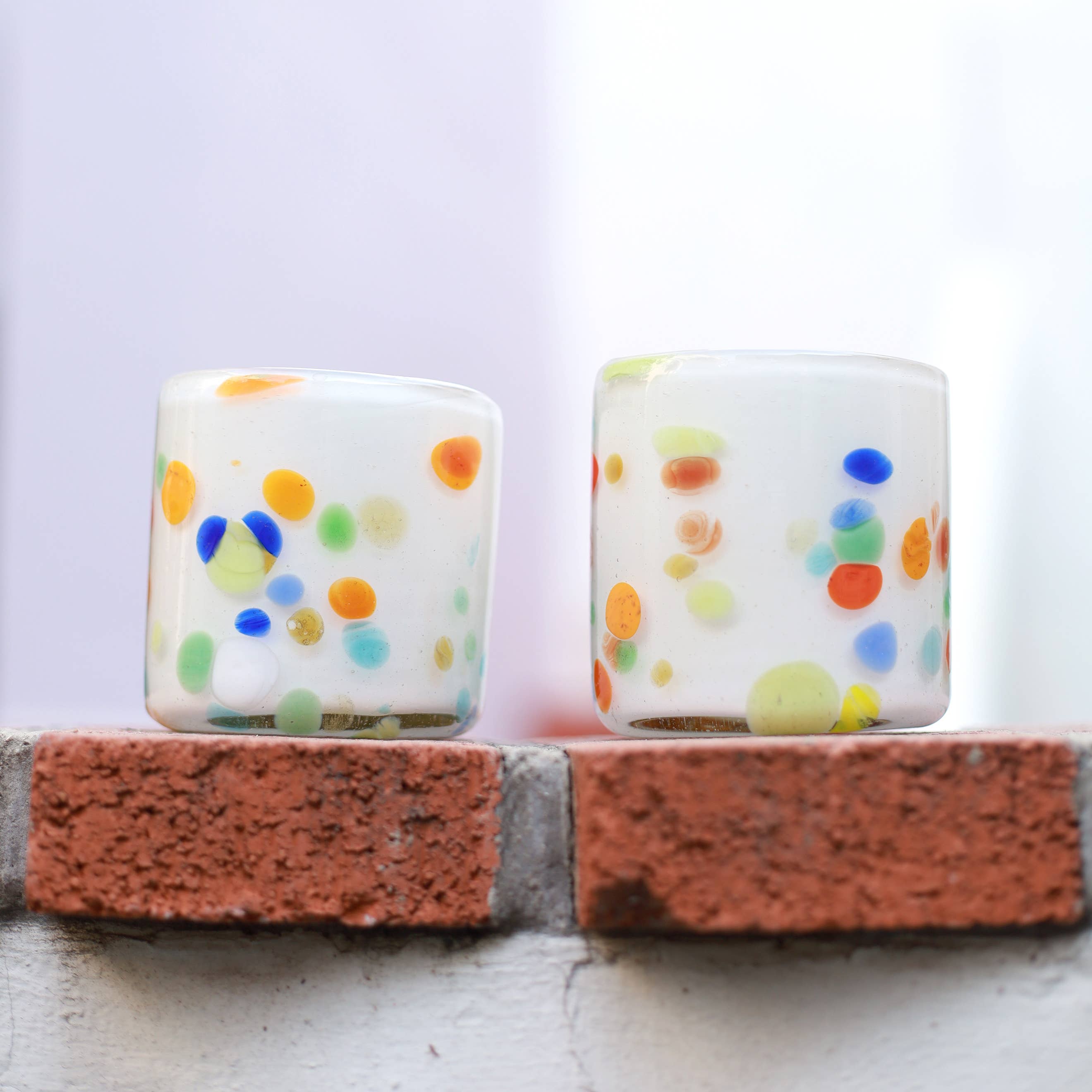 This vibrant, speckled green tumbler is hand blown in a family-run workshop, making each piece truly one-of-a-kind. Subtle variations in size and swirling color patterns mean no two are alike. Perfect for wine, cocktails, or even as a charming candle holder, it brings a touch of artistry and personality to any table.