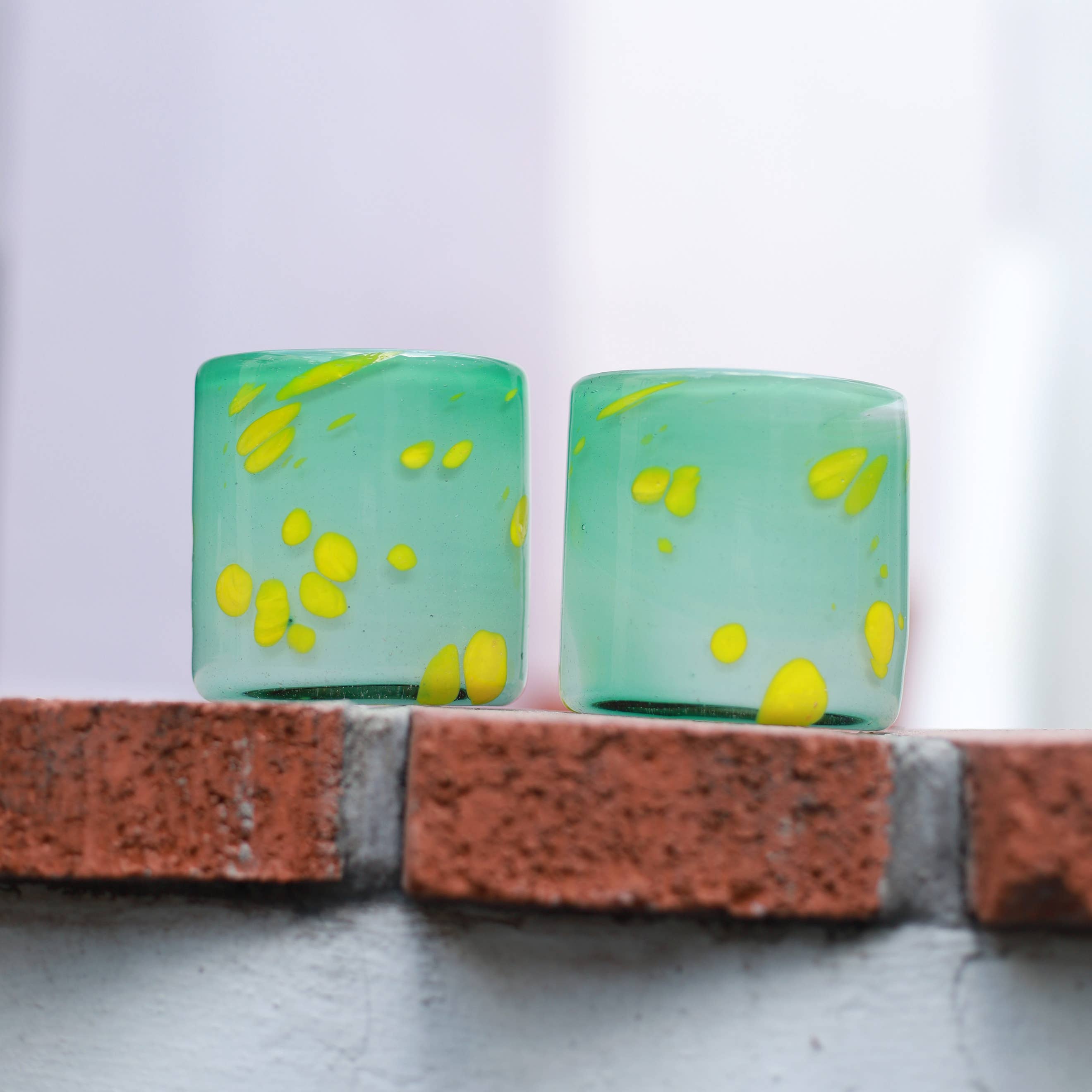 This vibrant, speckled green tumbler is hand blown in a family-run workshop, making each piece truly one-of-a-kind. Subtle variations in size and swirling color patterns mean no two are alike. Perfect for wine, cocktails, or even as a charming candle holder, it brings a touch of artistry and personality to any table.