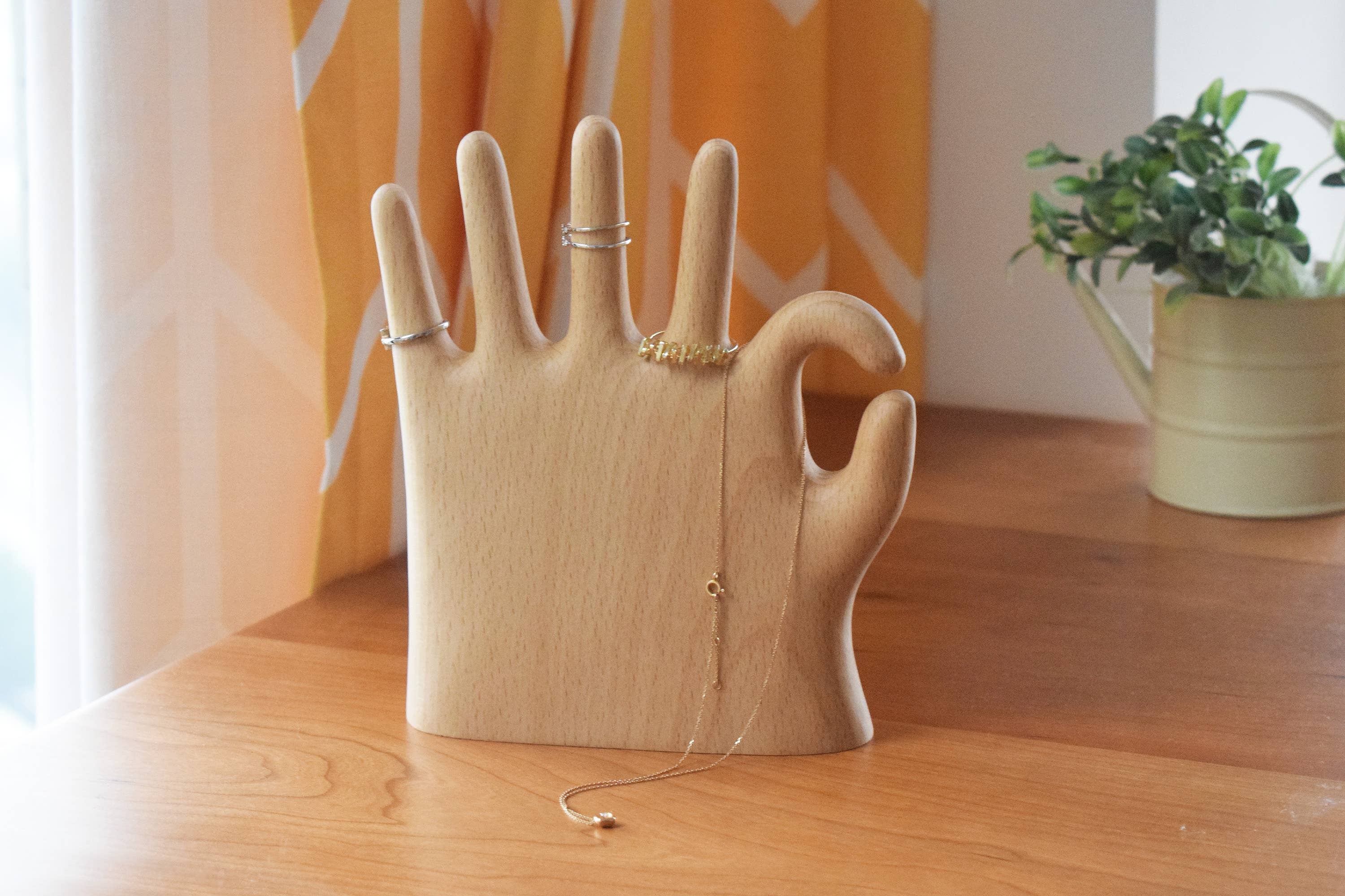 Show off your rings, necklaces, and bracelets with a touch of whimsy. This beech wood jewelry display features a hand making the classic “OK” sign with a playful twist: one extra finger (6 in total) to hold even more of your favorite pieces. Perfect for keeping your jewelry organized and adding a fun, eye-catching accent to your dresser or vanity.