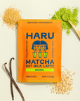Haru Matcha Oat Milk Latte package with matcha powder, oats, and vanilla beans on a beige background