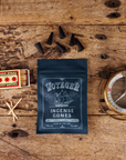 Voyaged Incense Cones packaging on a wooden surface with matches and a compass.
