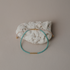 Seafoam and green beaded silk bracelet draped over a white stone