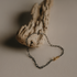 Black steel Jezebel chain bracelet draped over driftwood