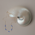 Kaleid necklace with periwinkle and cream bead sections draped over a nautilus shell on gray