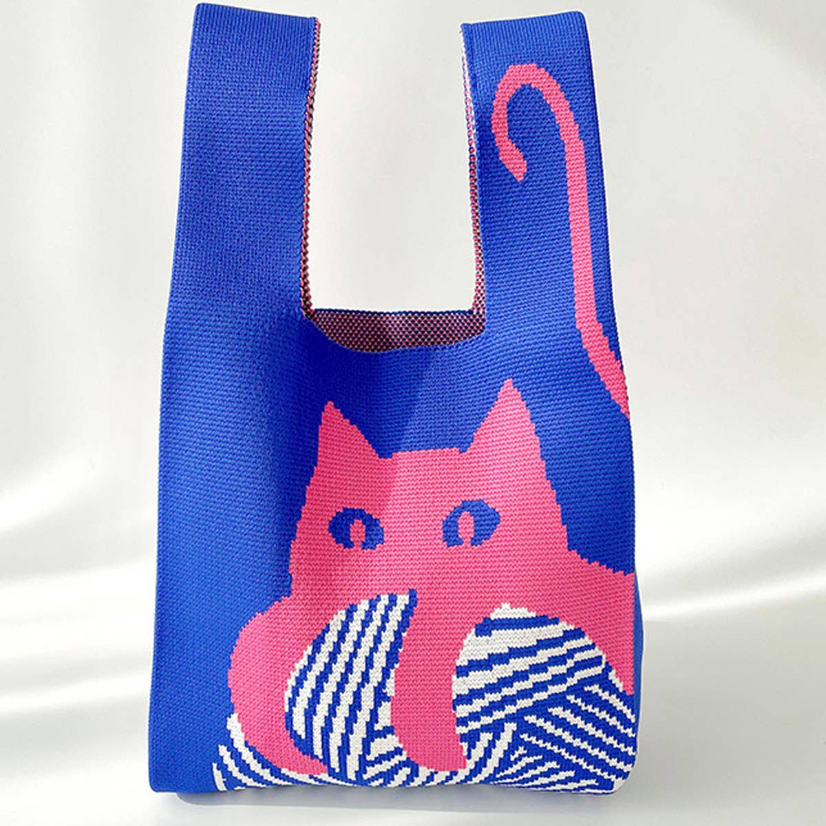 Add a playful pop to your look with this knitted shoulder bag featuring a whimsical blue and red cat graphic. Soft and lightweight, it’s perfect for carrying your essentials while adding a fun, artistic touch to any outfit. The roomy, flexible design makes it a charming everyday companion.