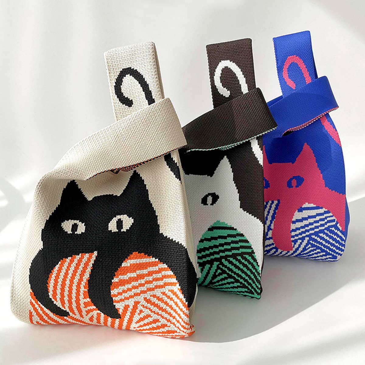 Add a playful pop to your look with this knitted shoulder bag featuring a whimsical blue and red cat graphic. Soft and lightweight, it’s perfect for carrying your essentials while adding a fun, artistic touch to any outfit. The roomy, flexible design makes it a charming everyday companion.