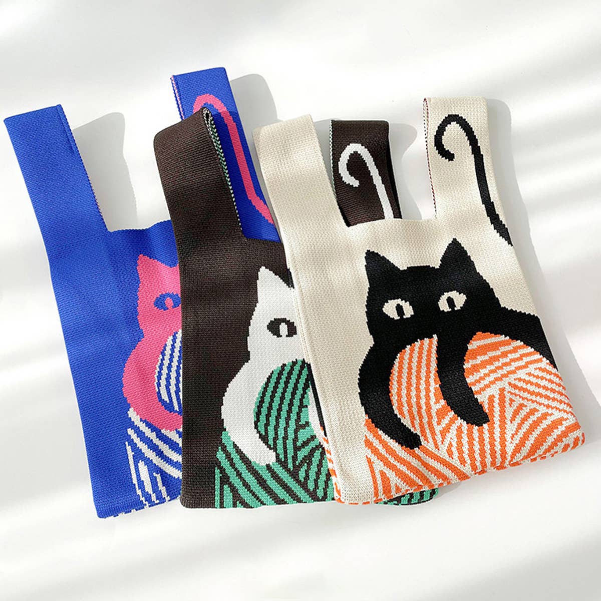 Add a playful pop to your look with this knitted shoulder bag featuring a whimsical blue and red cat graphic. Soft and lightweight, it’s perfect for carrying your essentials while adding a fun, artistic touch to any outfit. The roomy, flexible design makes it a charming everyday companion.