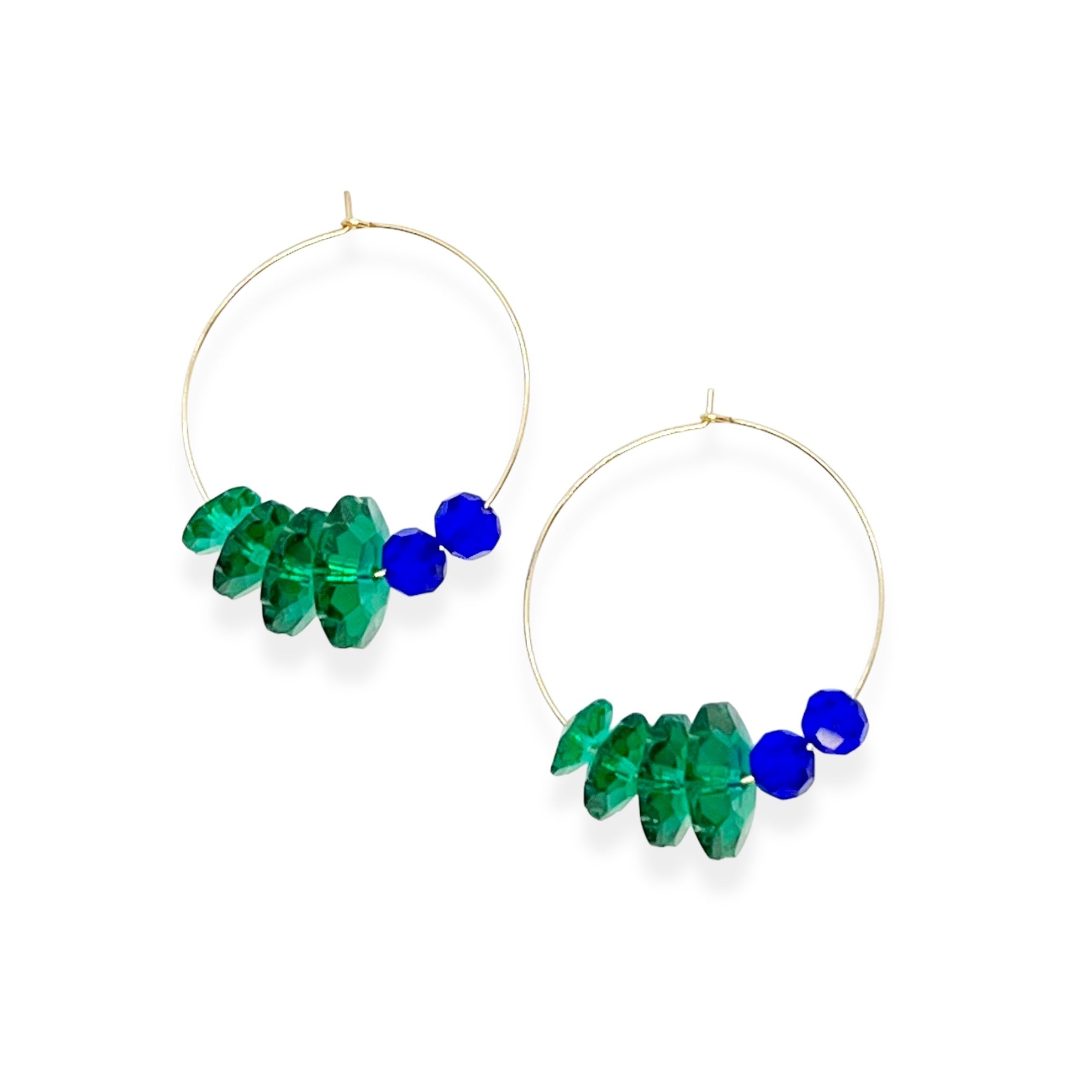 Designed with sculptural flow and oceanic calm, the Large Anchor Hoops feature descending teal floral crystals that create a cascading shape. Finished with two rich cobalt stones for balance, these hoops embody a quiet strength and grounded beauty that stands out without shouting.