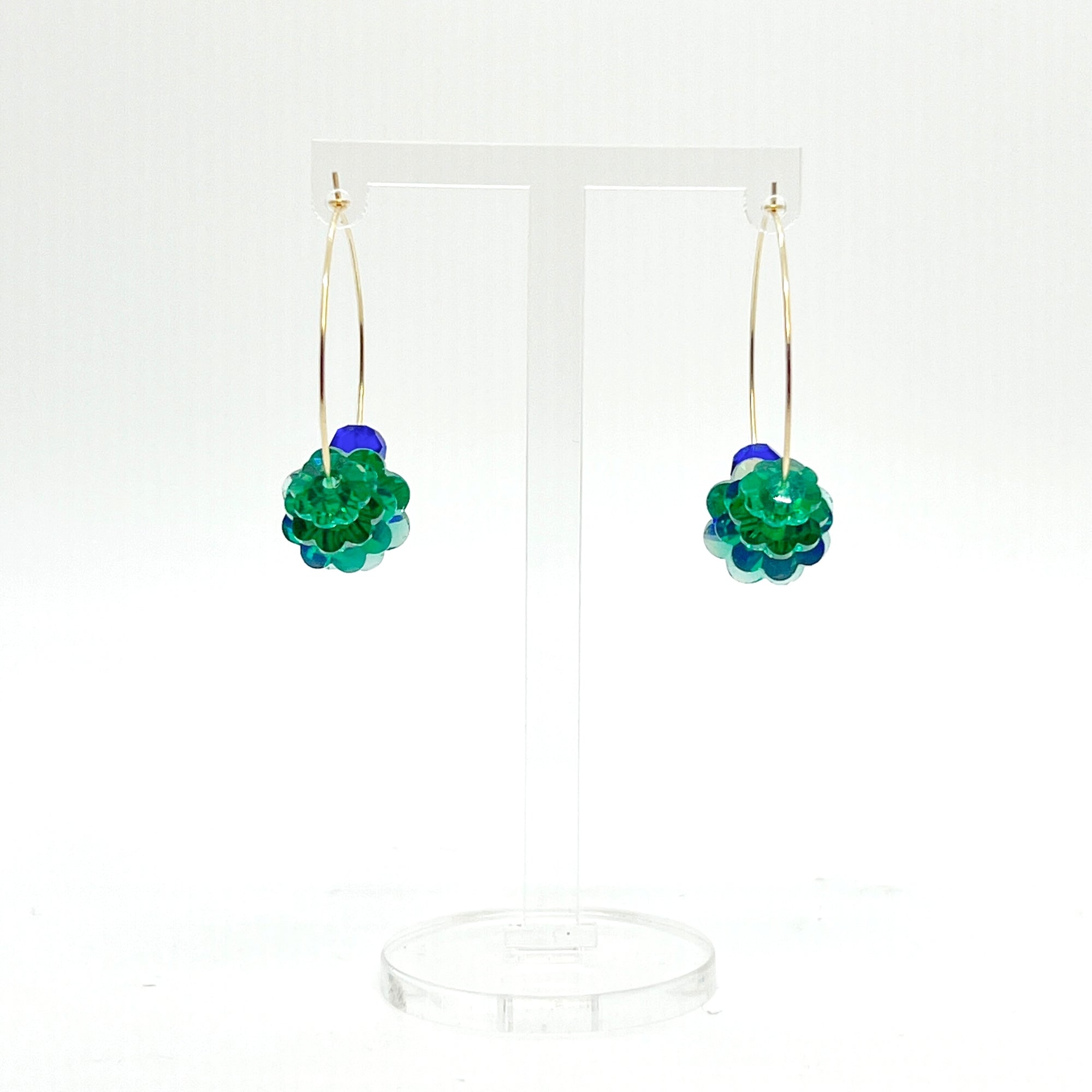 Designed with sculptural flow and oceanic calm, the Large Anchor Hoops feature descending teal floral crystals that create a cascading shape. Finished with two rich cobalt stones for balance, these hoops embody a quiet strength and grounded beauty that stands out without shouting.