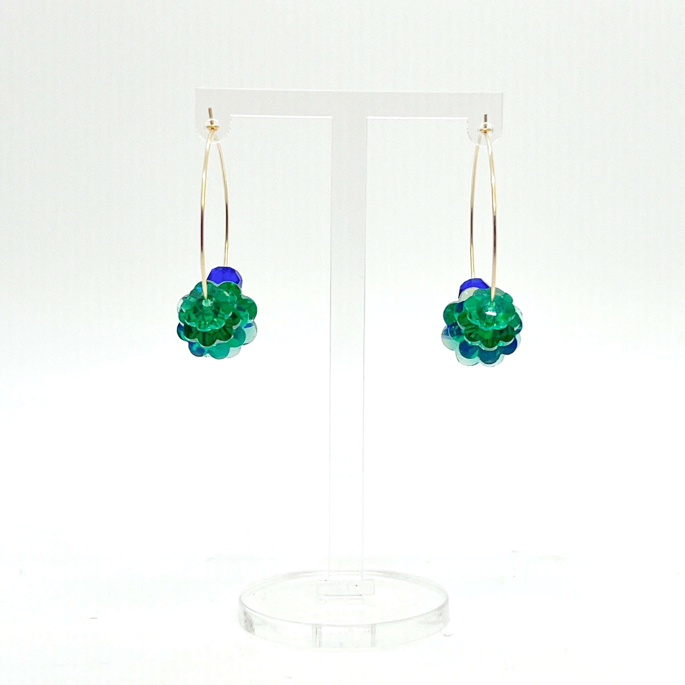 Designed with sculptural flow and oceanic calm, the Large Anchor Hoops feature descending teal floral crystals that create a cascading shape. Finished with two rich cobalt stones for balance, these hoops embody a quiet strength and grounded beauty that stands out without shouting.