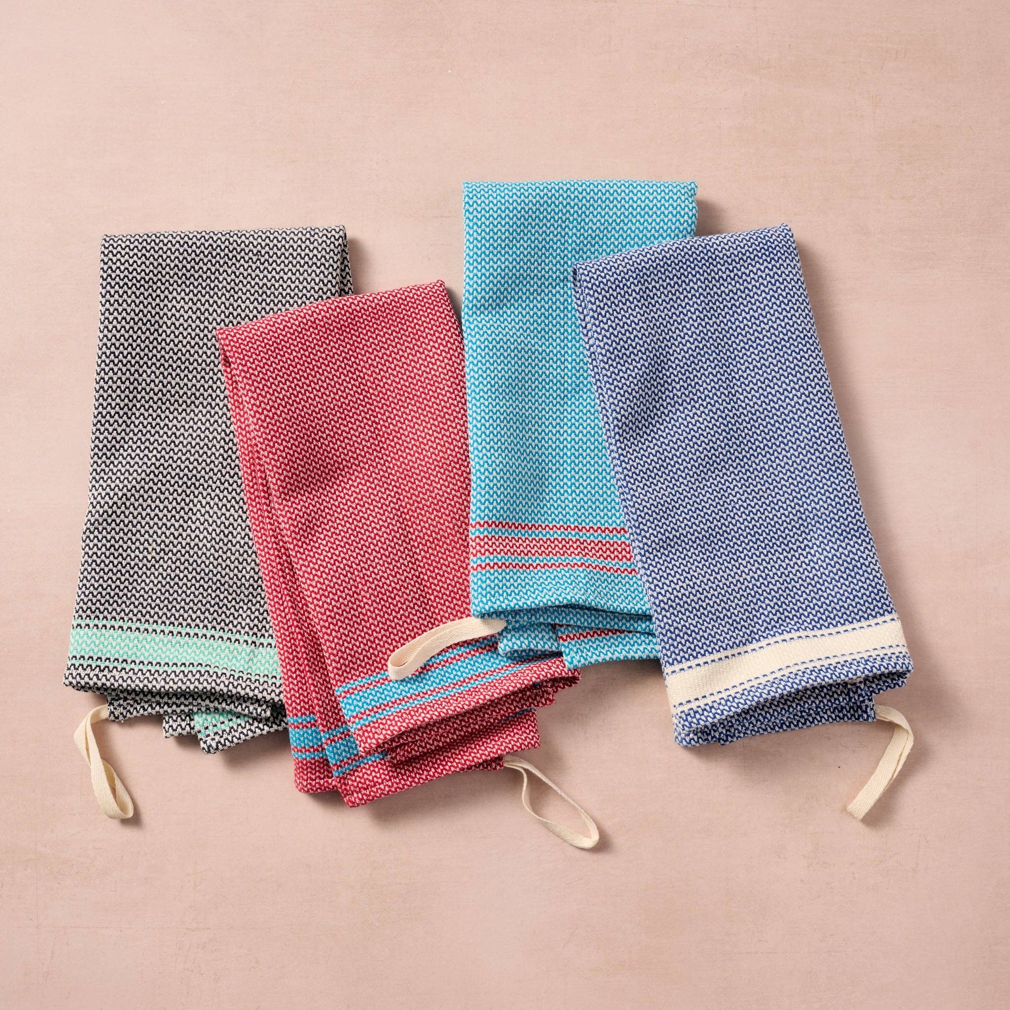 Brighten your kitchen with a pop of color and timeless charm. This striped woven tea towel blends function with simple elegance, featuring a refreshing aqua and white base accented by three bold red stripes at each end. Crafted from 100% cotton, it’s soft, absorbent and ready to tackle daily tasks - from drying dishes to lining a breadbasket. A convenient cotton loop in the corner makes it easy to hang and display. Whether you’re cooking up memories or cleaning up spills, this towel adds a cheerful, artisan