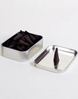 Indulge in the rich aromas of Big Bend National Park with Good &amp; Well Supply Co's hand-dipped incense cones. Encased in a robust aluminum tin, these cones are thoughtfully designed, with the lid serving as a convenient burning surface. With notes of charred wood, amber, smoky embers, and spice, you'll be transported to an evening camping in Big Bend.&nbsp;