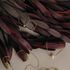Gold chain jewelry with peach pearls laid over dark red leaves