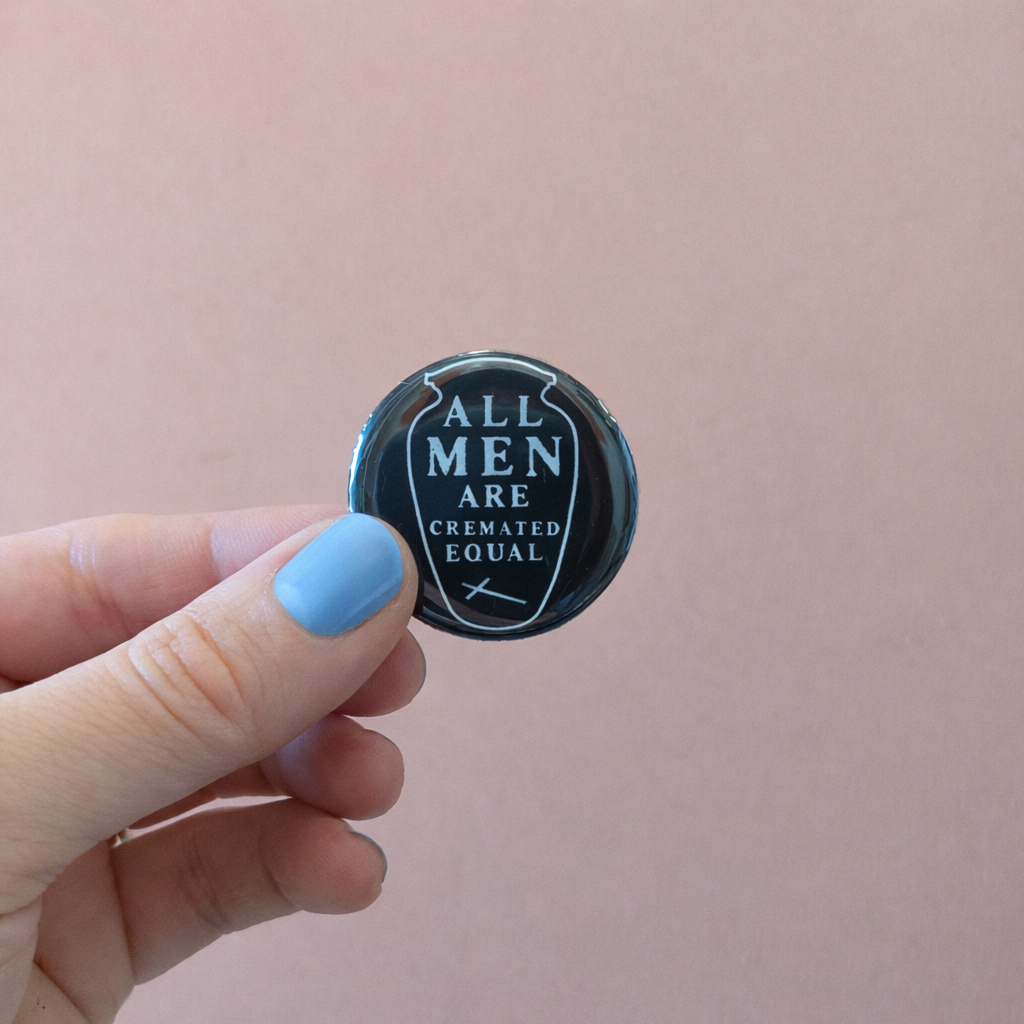 A little dark humor for your jacket, bag, or wherever you pin your personality. 'All Men Are Cremated Equal' — a reminder that in the end, the flames don't play favorites. Pin it loud, pin it proud.