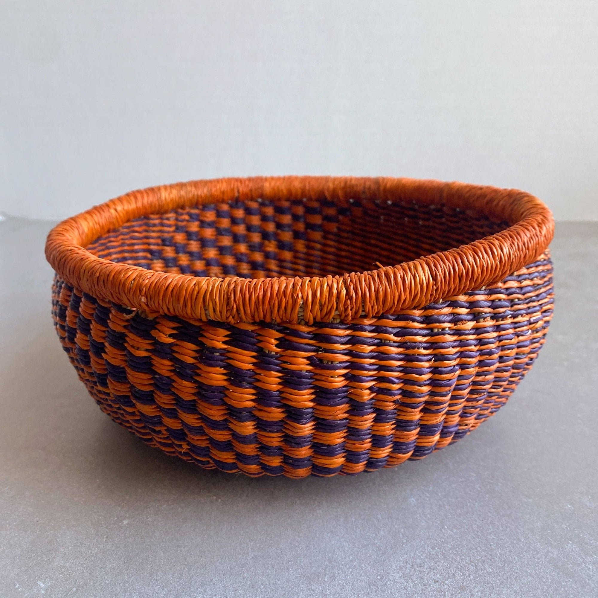 Decorate your home with a Round Bolga Basket, handwoven by experienced women in Ghana's Bolgatanga region using locally sourced veta vera grass. Each basket is woven wet and can be re-shaped by adding water. Durable and washable, these baskets are a beautiful and unique addition to your decor. Fun fact: kinkahe is a local name for veta vera grass in Ghana!