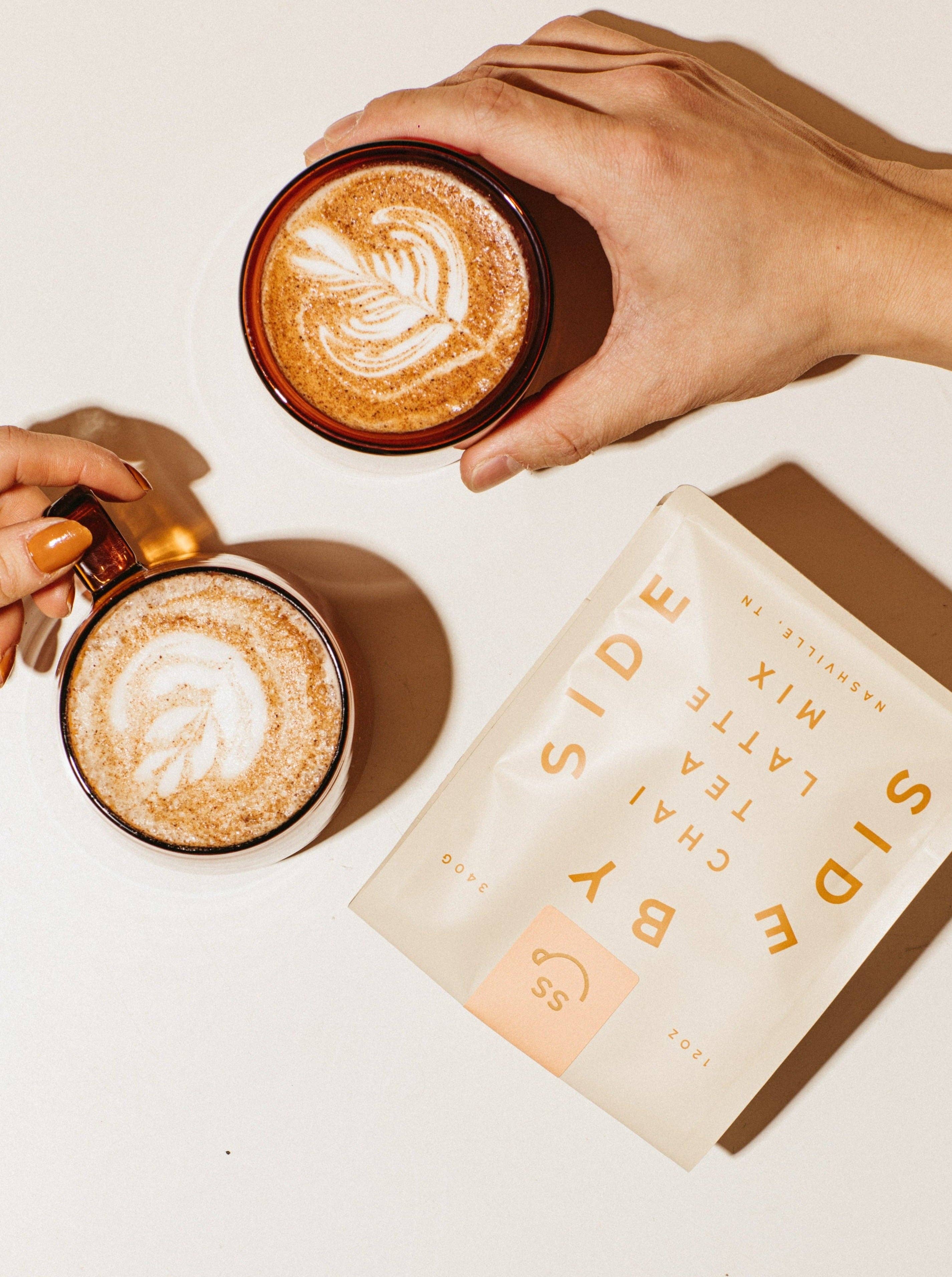 Two hands holding mugs