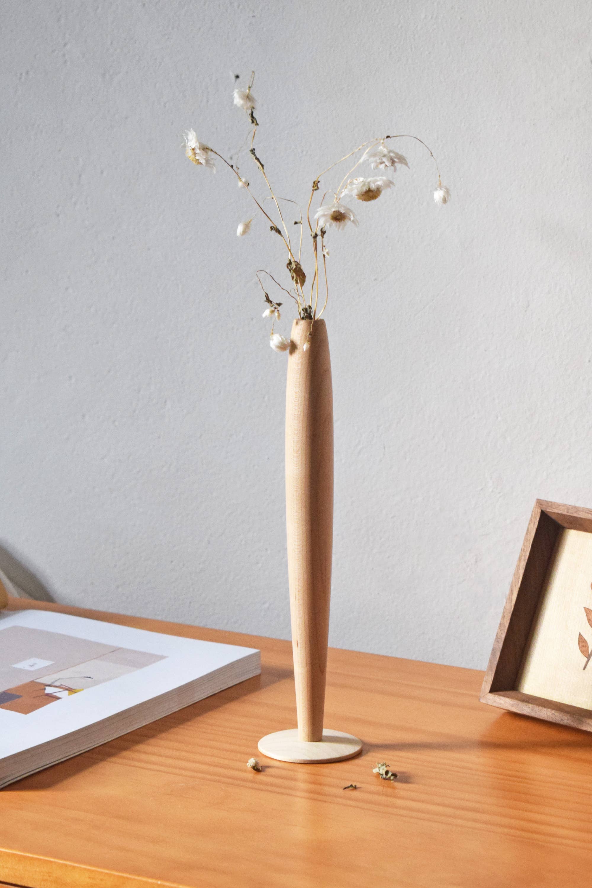 Crafted from fine maple wood and delicately polished, this single flower vase embodies the elegance of Eastern Zen aesthetics. Minimal yet refined, it adds a serene touch to any space—perfect for home décor or as a thoughtful housewarming gift.