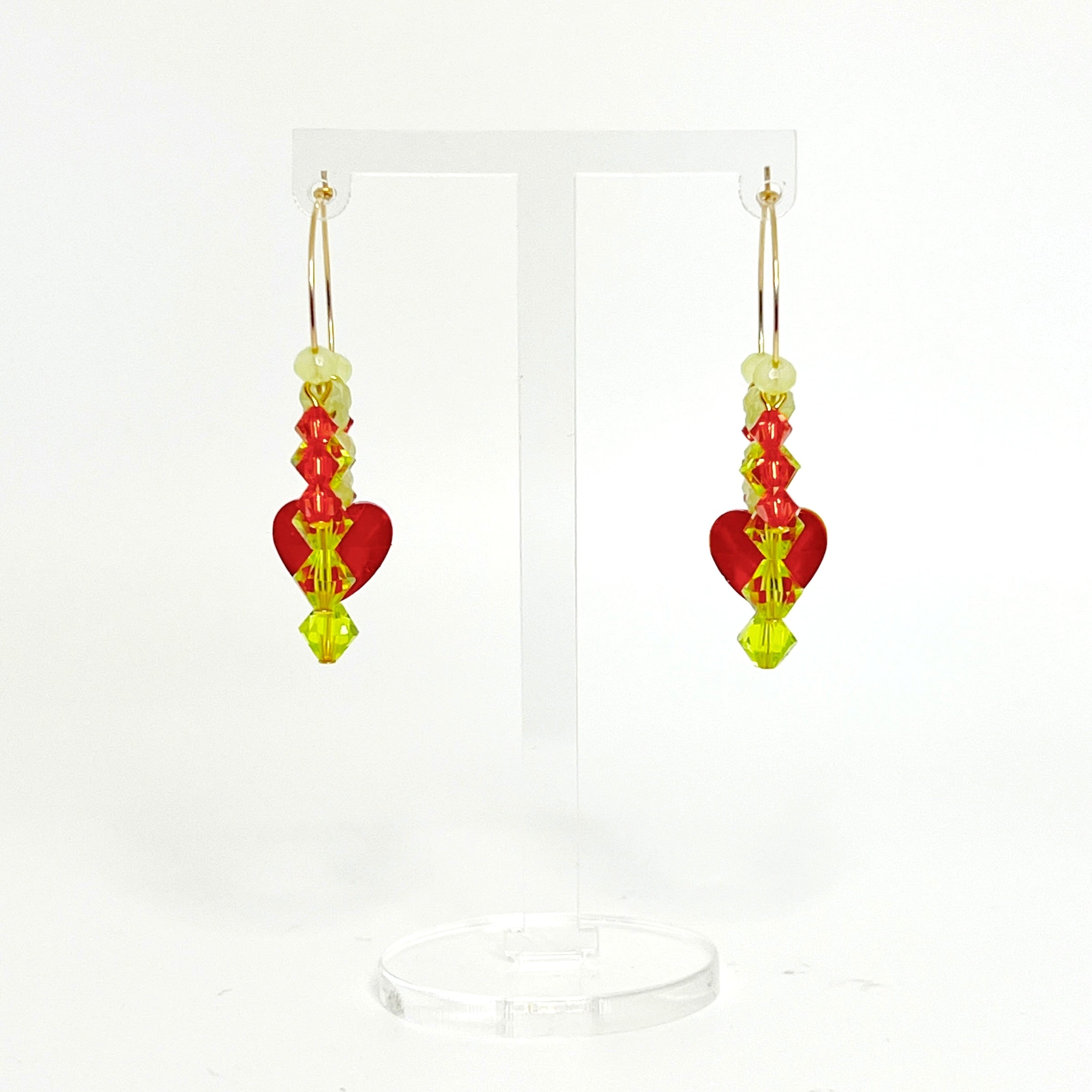 Joyful, flirty, and full of energy—these Small Spark Hoops are a burst of personality. A radiant heart-shaped crystal takes center stage, framed by watermelon and chartreuse tones that feel like summer bottled up. A scattering of dangling crystals adds playful movement, making these hoops perfect for anyone who loves to stand out and shine.