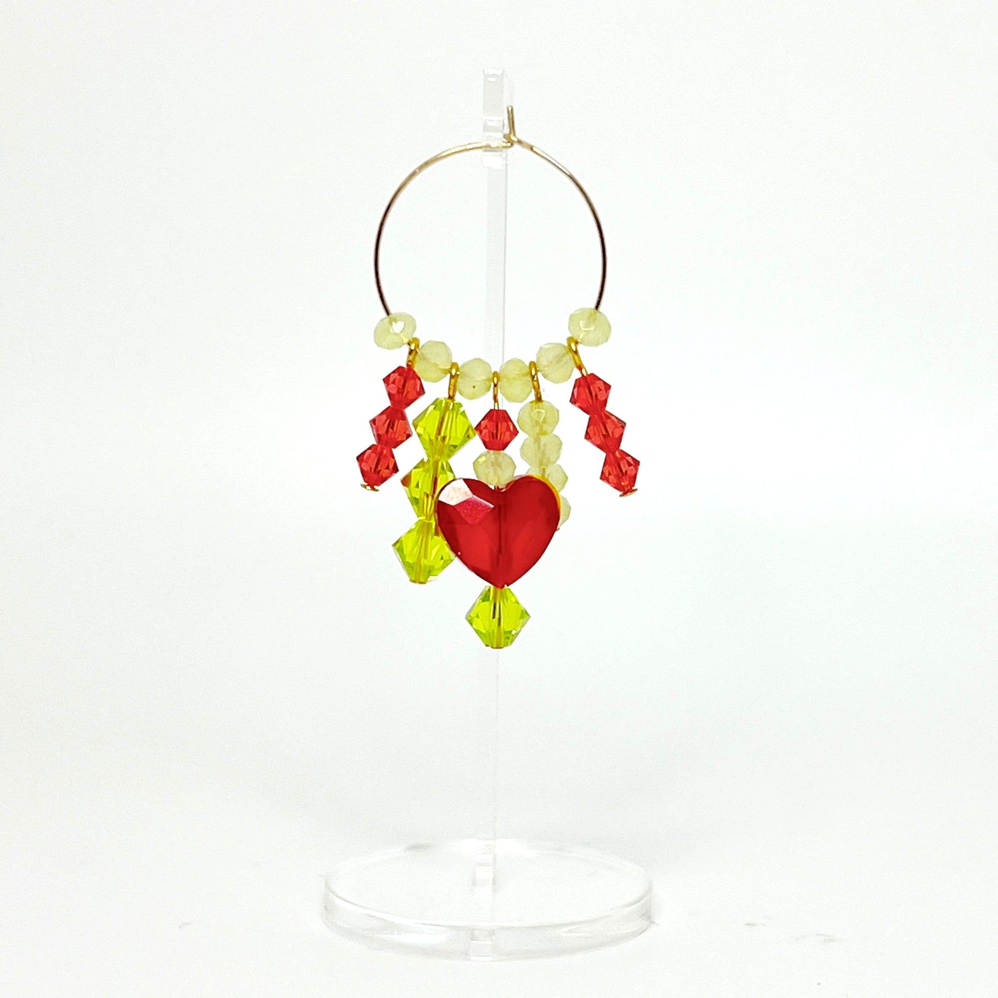 Joyful, flirty, and full of energy—these Small Spark Hoops are a burst of personality. A radiant heart-shaped crystal takes center stage, framed by watermelon and chartreuse tones that feel like summer bottled up. A scattering of dangling crystals adds playful movement, making these hoops perfect for anyone who loves to stand out and shine.