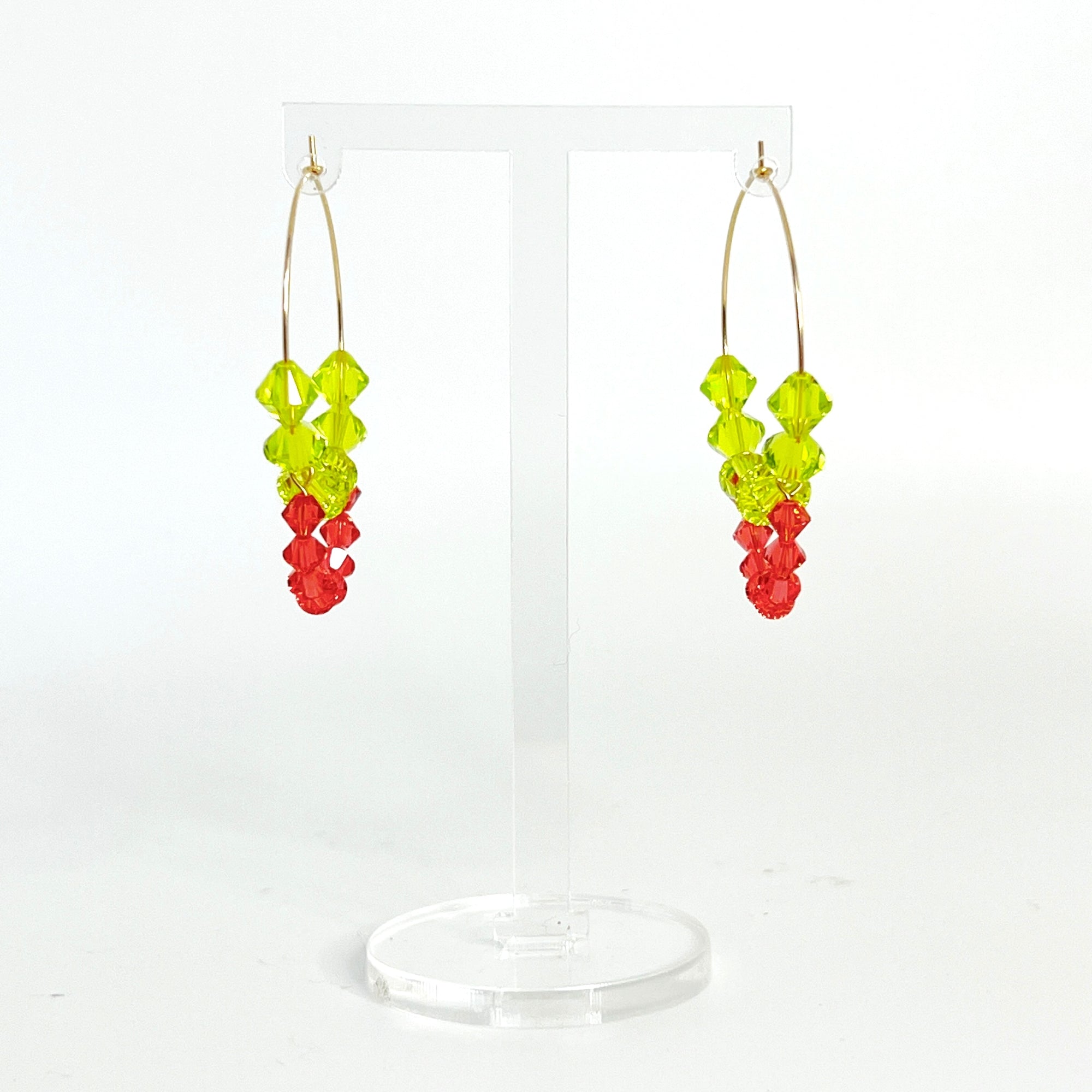 Joyful, flirty, and full of energy—these Small Spark Hoops are a burst of personality. A radiant heart-shaped crystal takes center stage, framed by watermelon and chartreuse tones that feel like summer bottled up. A scattering of dangling crystals adds playful movement, making these hoops perfect for anyone who loves to stand out and shine.