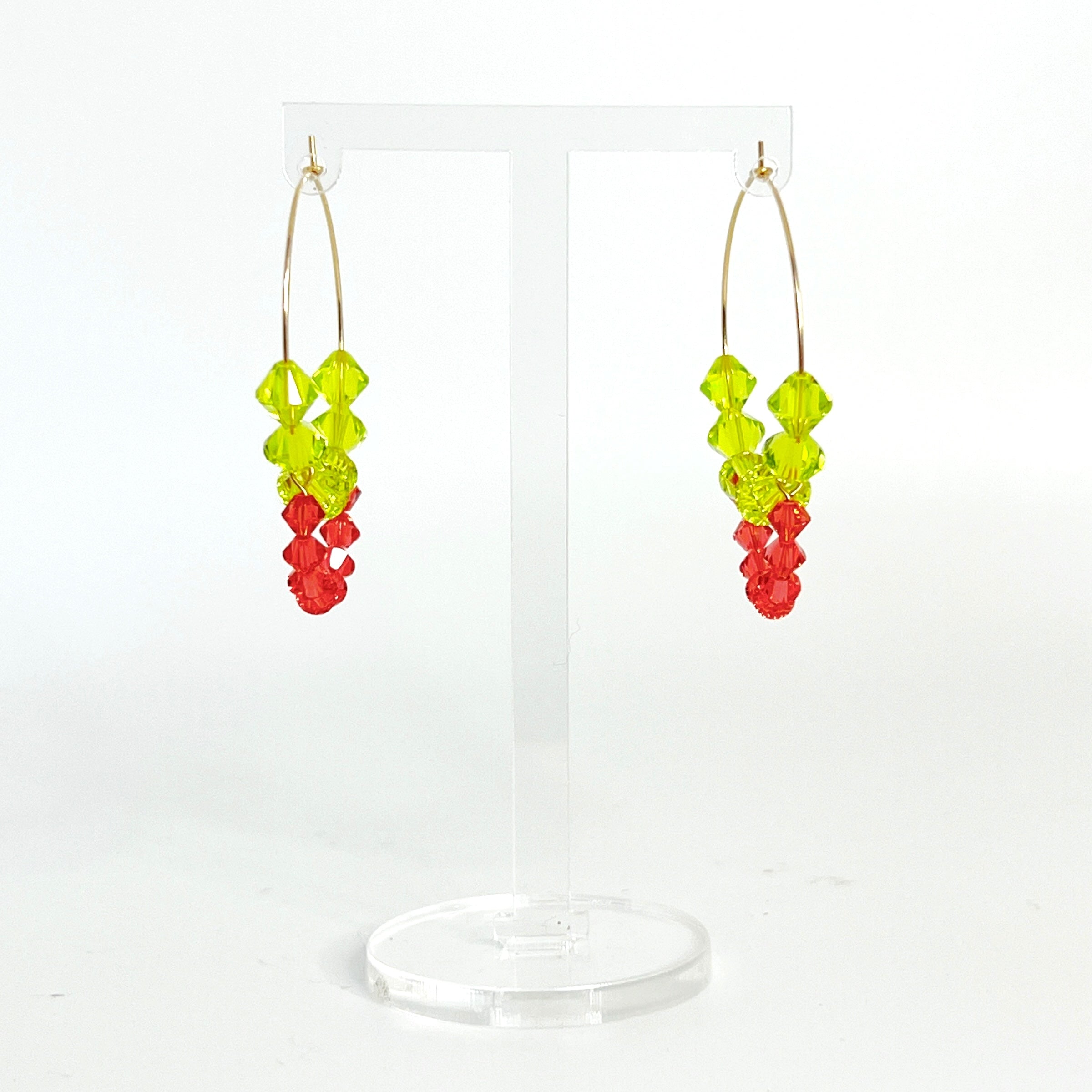 Joyful, flirty, and full of energy—these Small Spark Hoops are a burst of personality. A radiant heart-shaped crystal takes center stage, framed by watermelon and chartreuse tones that feel like summer bottled up. A scattering of dangling crystals adds playful movement, making these hoops perfect for anyone who loves to stand out and shine.