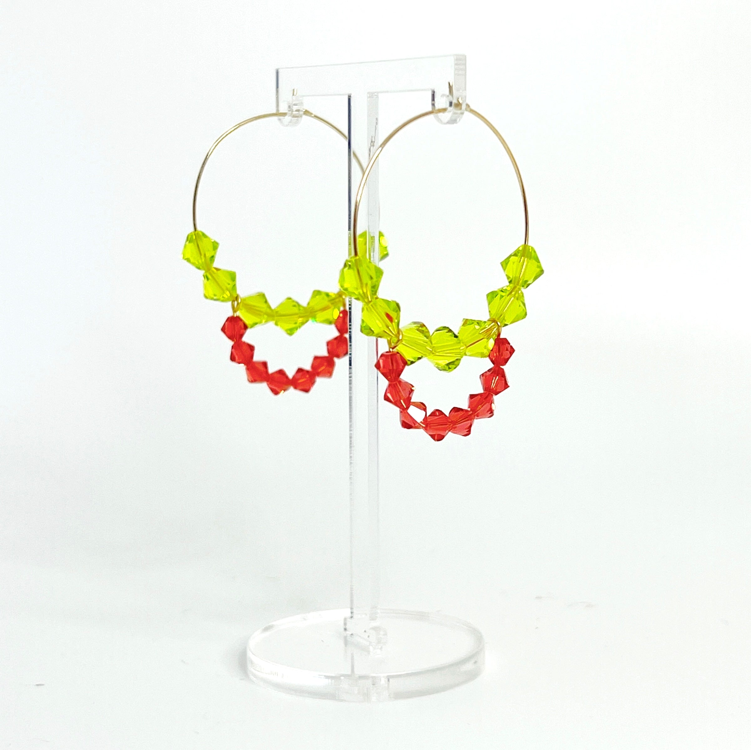 Joyful, flirty, and full of energy—these Small Spark Hoops are a burst of personality. A radiant heart-shaped crystal takes center stage, framed by watermelon and chartreuse tones that feel like summer bottled up. A scattering of dangling crystals adds playful movement, making these hoops perfect for anyone who loves to stand out and shine.