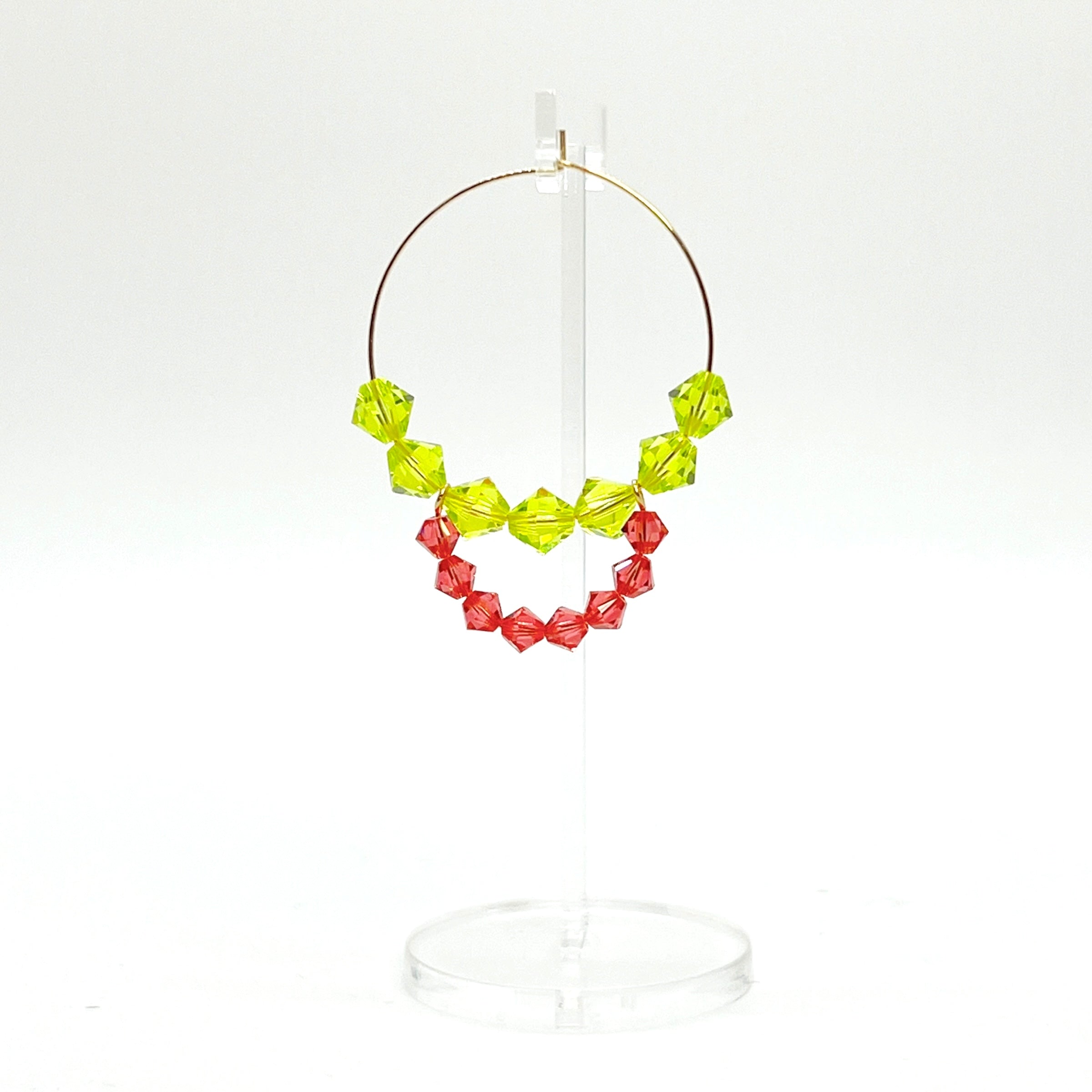 Joyful, flirty, and full of energy—these Small Spark Hoops are a burst of personality. A radiant heart-shaped crystal takes center stage, framed by watermelon and chartreuse tones that feel like summer bottled up. A scattering of dangling crystals adds playful movement, making these hoops perfect for anyone who loves to stand out and shine.