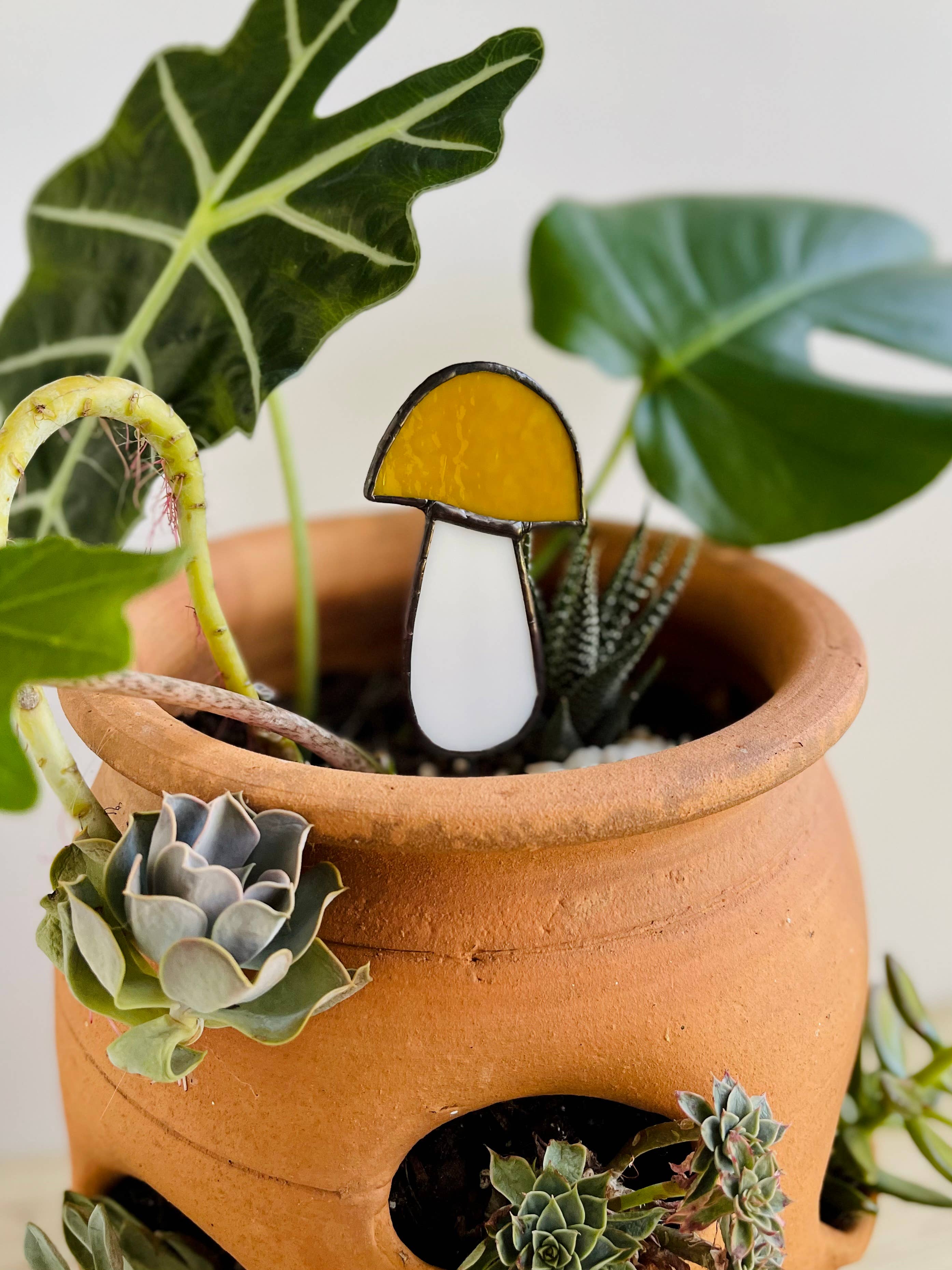Handcrafted amber stained glass mushroom adds charm to plants or gardens. Weatherproof and pet-safe. Perfect for unique home decor and garden gifts.