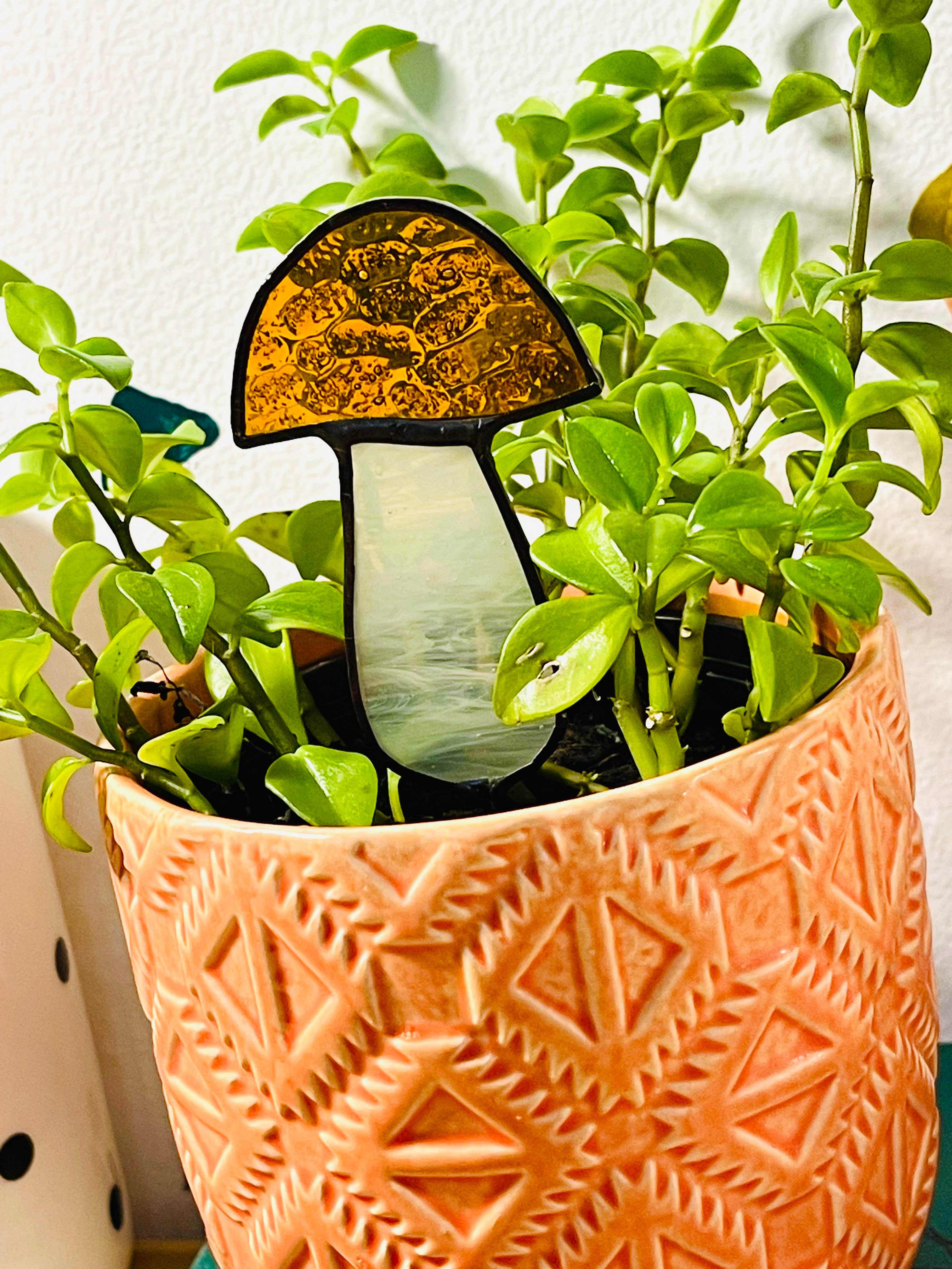 Handcrafted amber stained glass mushroom adds charm to plants or gardens. Weatherproof and pet-safe. Perfect for unique home decor and garden gifts.