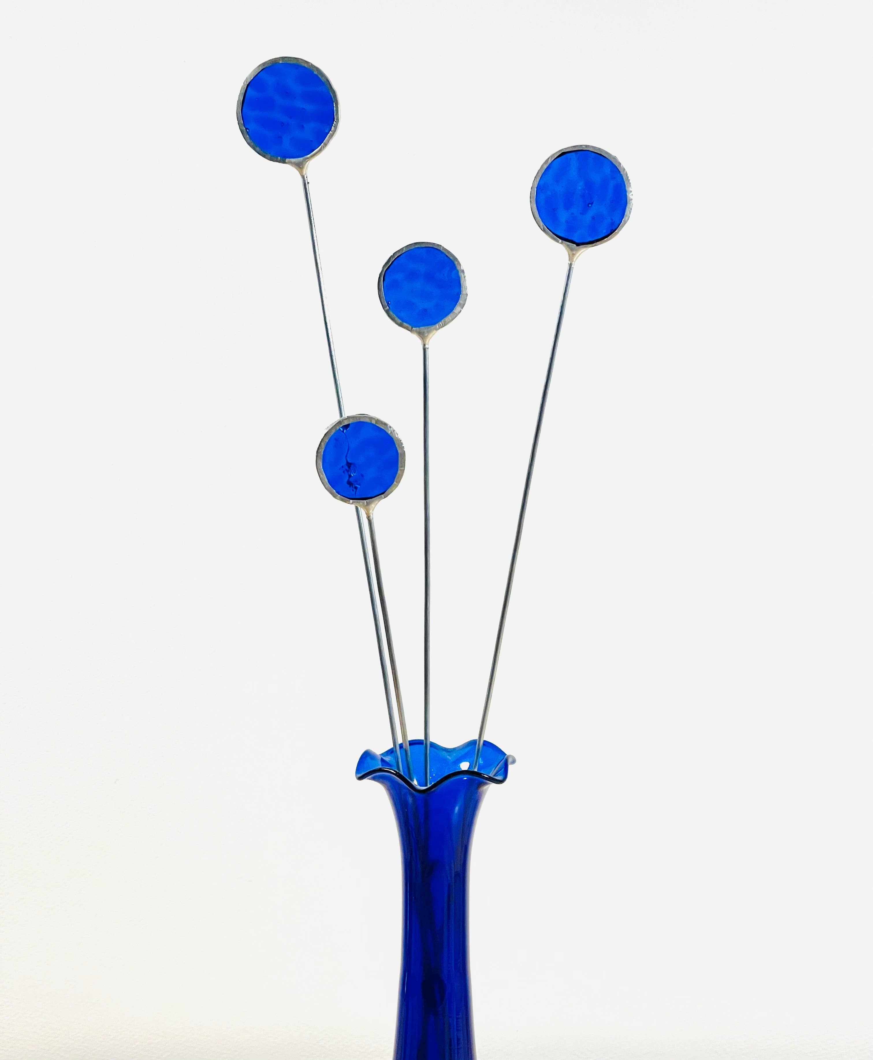 Bring a pop of color and artistry to your home with this handcrafted set of stained glass blue globe thistles by Samara Designs Studio. Each stem is carefully handmade using cobalt blue stained glass, cut and assembled with care to create a lasting botanical accent that will never wilt or fade.