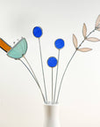 Bring a pop of color and artistry to your home with this handcrafted set of stained glass blue globe thistles by Samara Designs Studio. Each stem is carefully handmade using cobalt blue stained glass, cut and assembled with care to create a lasting botanical accent that will never wilt or fade.