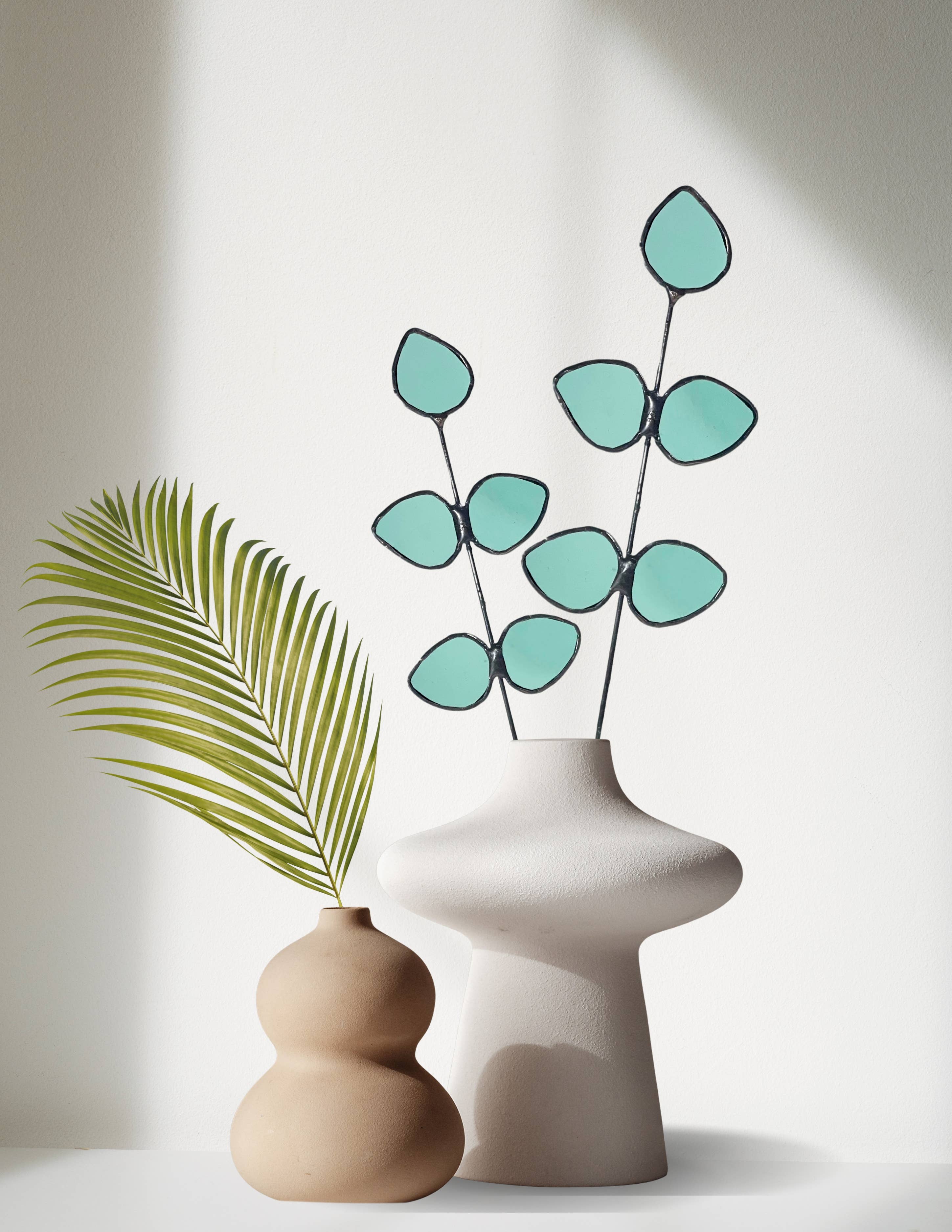 Bring a pop of color and artistry to your home with this handcrafted stained glass gumdrop eucalyptus stem by Samara Designs Studio. This stem is made from beautiful transparent seafoam green stained glass, cut and assembled by hand to create a lasting botanical accent that will never wilt or fade.