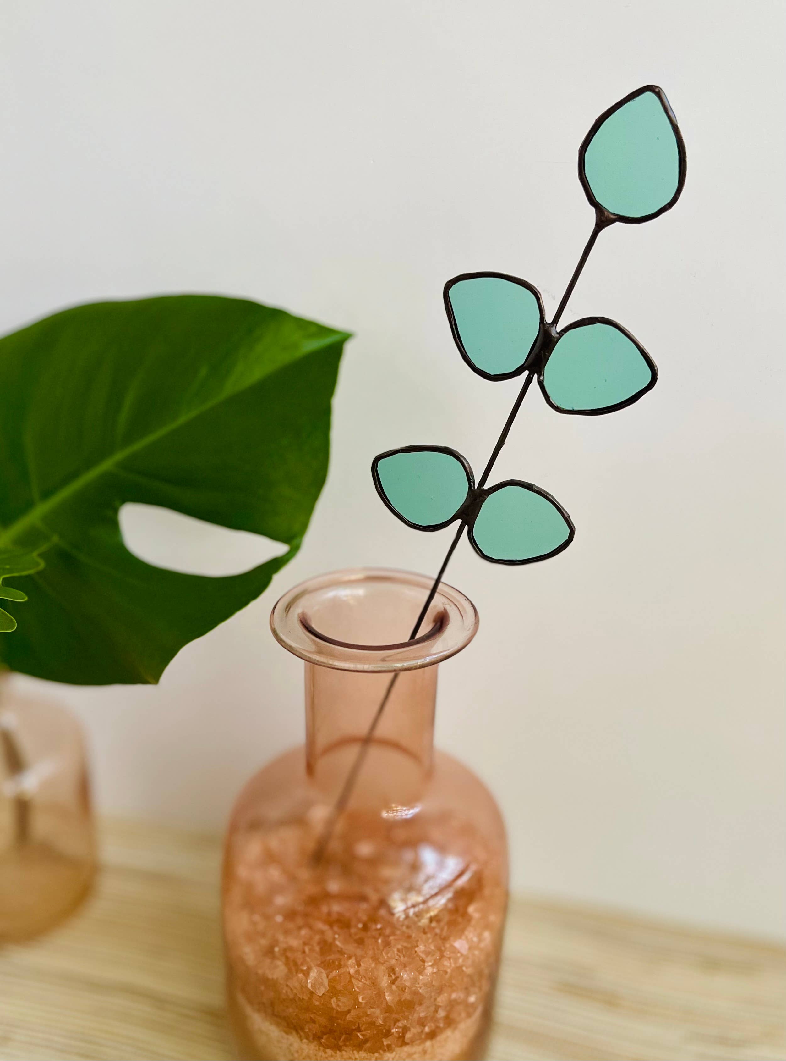 Bring a pop of color and artistry to your home with this handcrafted stained glass gumdrop eucalyptus stem by Samara Designs Studio. This stem is made from beautiful transparent seafoam green stained glass, cut and assembled by hand to create a lasting botanical accent that will never wilt or fade.