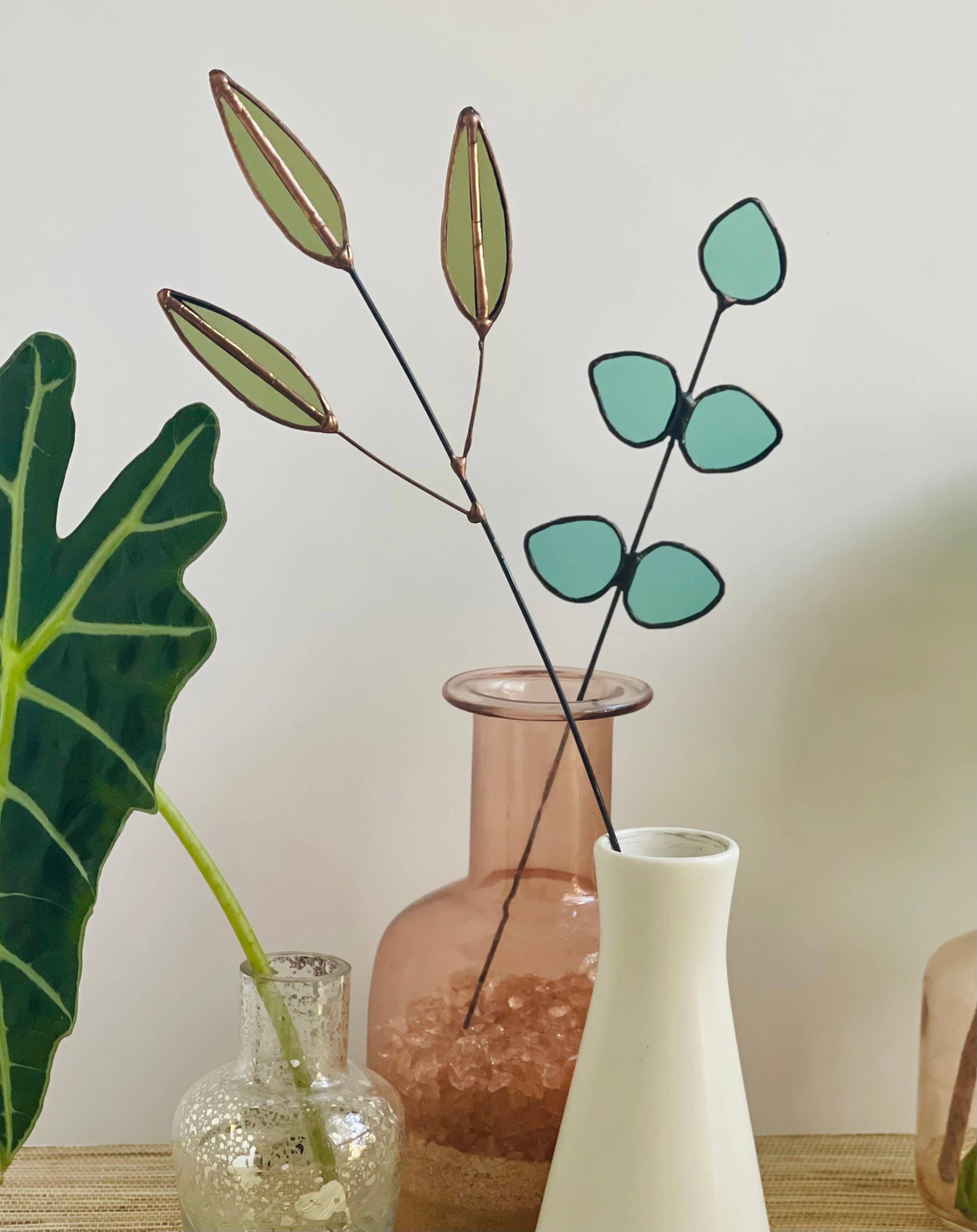 Bring a pop of color and artistry to your home with this handcrafted stained glass gumdrop eucalyptus stem by Samara Designs Studio. This stem is made from beautiful transparent seafoam green stained glass, cut and assembled by hand to create a lasting botanical accent that will never wilt or fade.