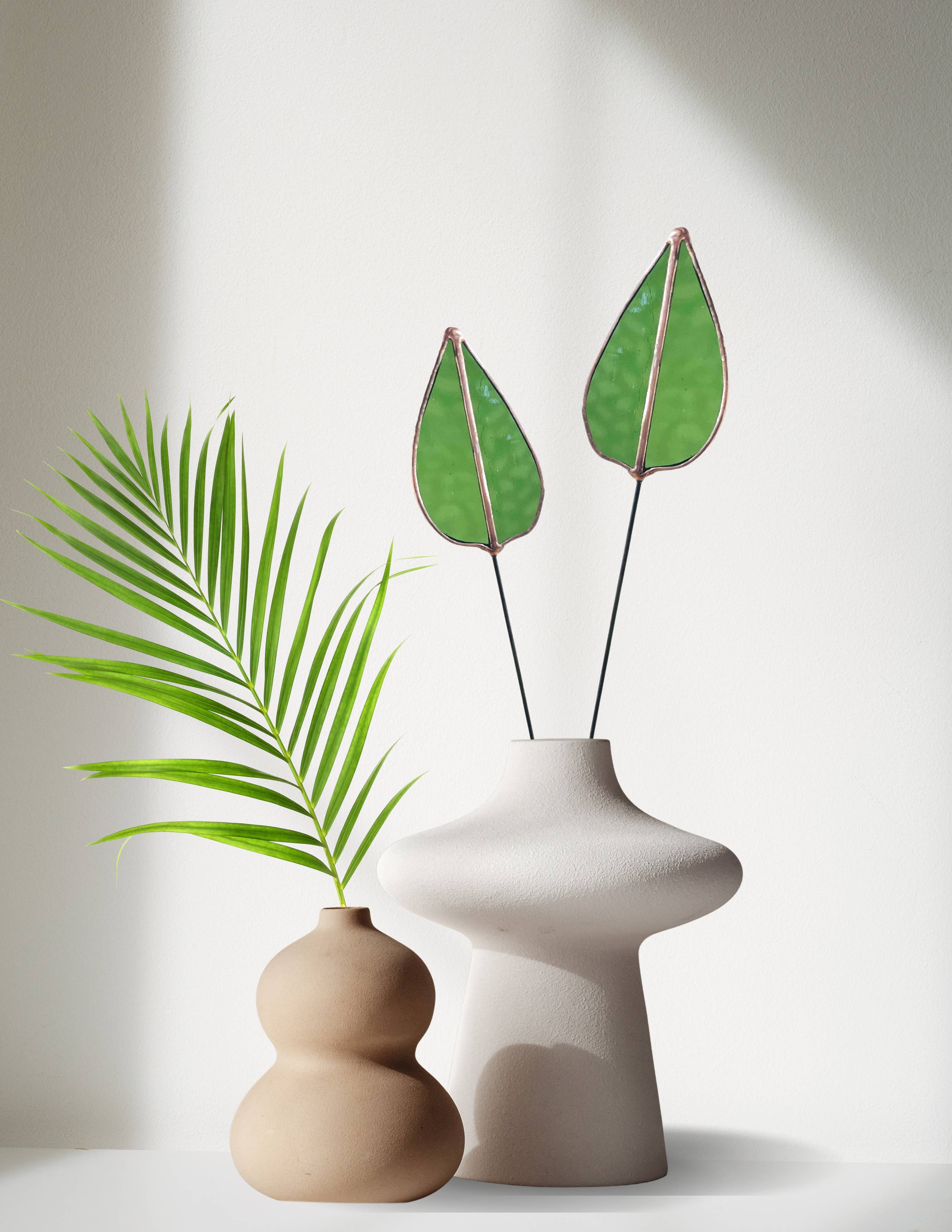 Bring a pop of color and artistry to your home with this handcrafted stained glass mulberry leaf stem by Samara Designs Studio. This stem is made from transparent earthy green stained glass with copper accents, evoking the solid, grounding tones of nature. Each piece is carefully handmade to create a lasting botanical accent that will never wilt or fade.
